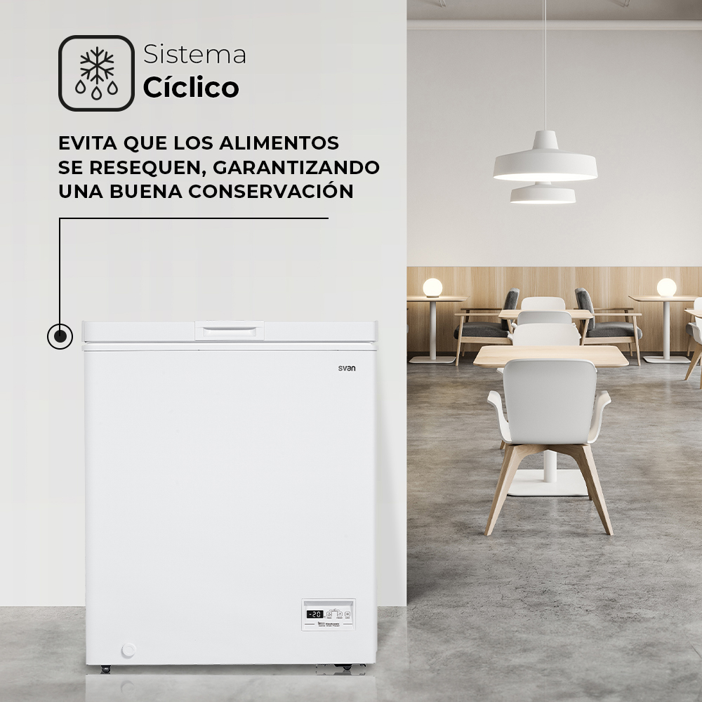 Un congelador de arcón blanco frente a una pared blanca con texto sobre la conservación de alimentos. Un comedor es visible.