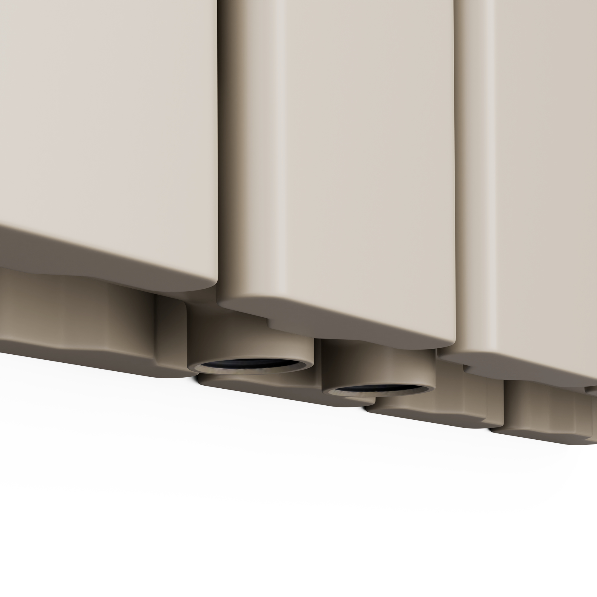 Primo piano di sezioni di radiatore beige con cerchi scuri. Lo sfondo è bianco.