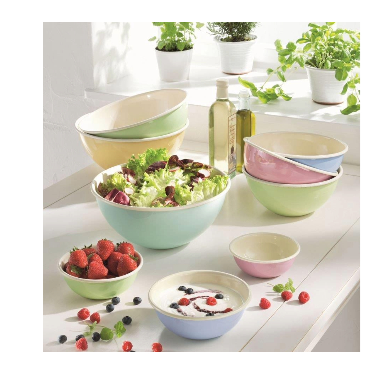 Bunte Schalen mit Salaten, Obst und Joghurt. Zutaten sind Salat, Erdbeeren und Blaubeeren.