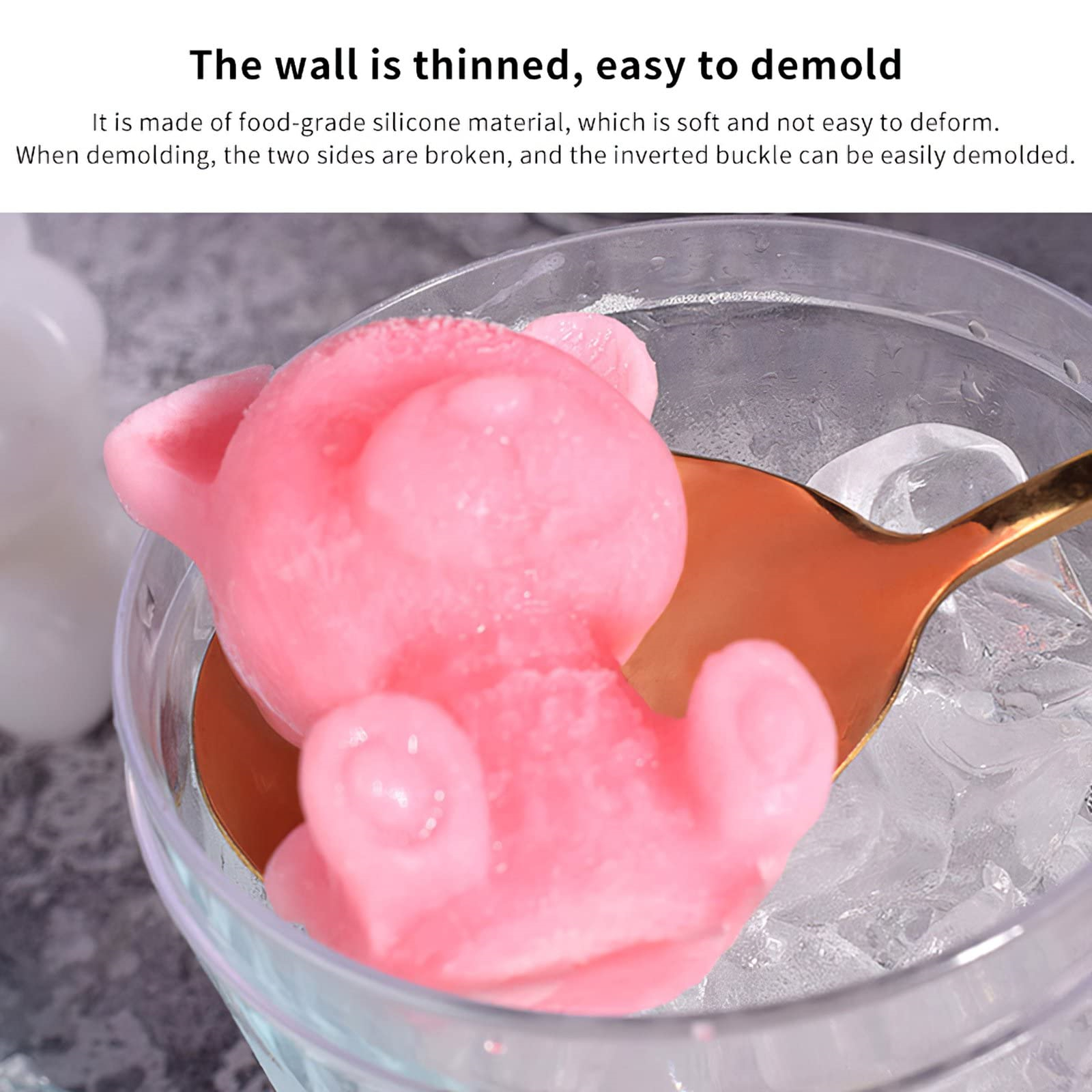Rosa Eis in Bärenform in einer Glasschale, mit Eiswürfeln und einem goldenen Löffel.