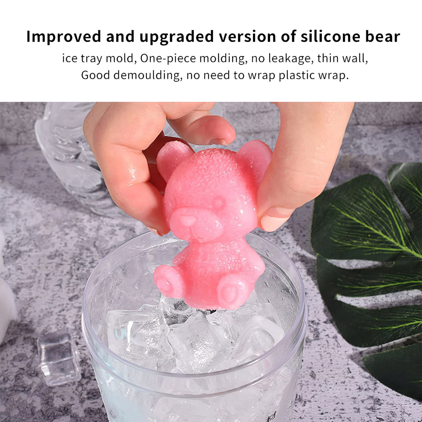Ein rosa, bärenförmiger Eiswürfel wird über einem Glas mit Eiswürfeln gehalten. Klares Glas.