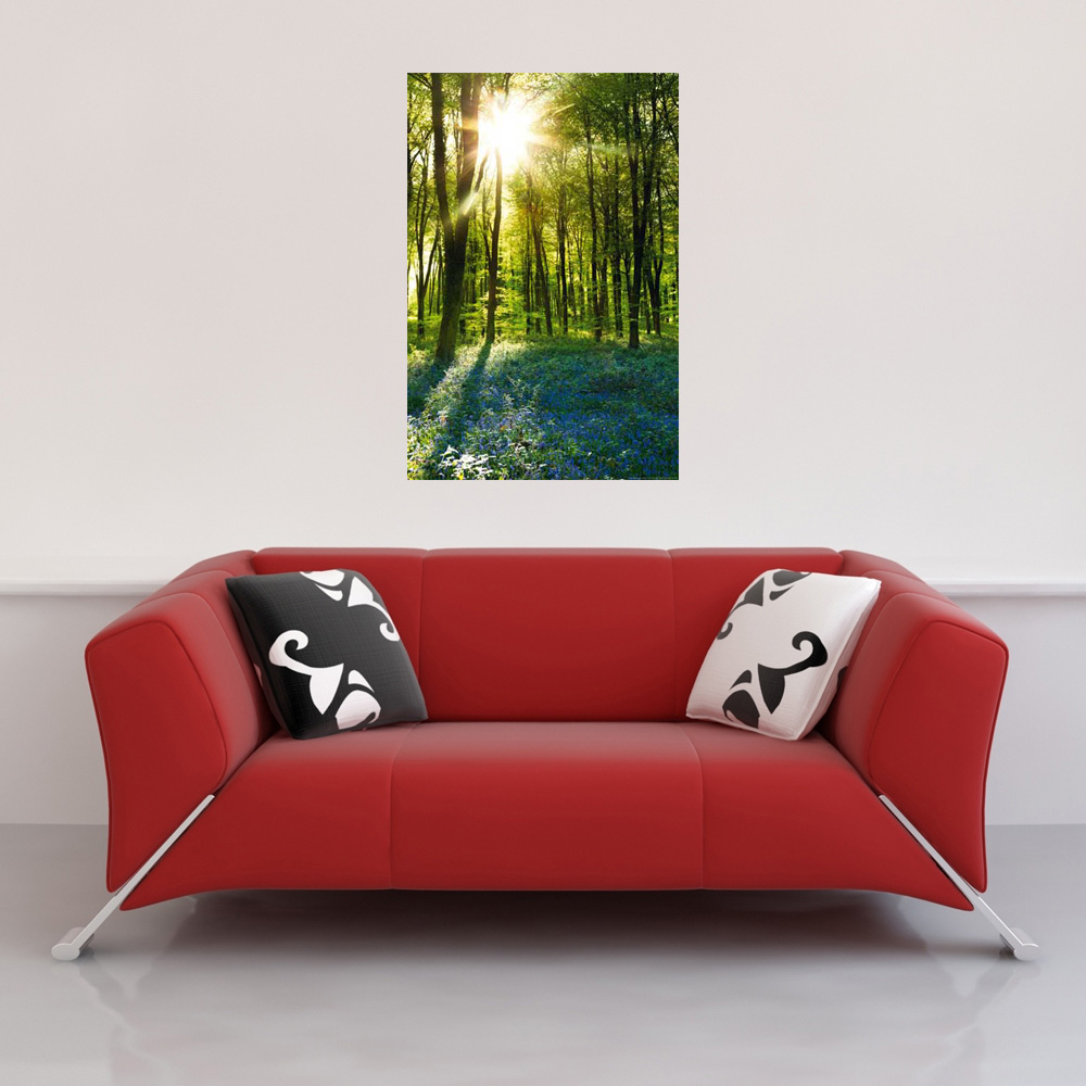 Ein rotes Sofa mit zwei dekorativen Kissen und einem gerahmten Bild einer Waldszene.