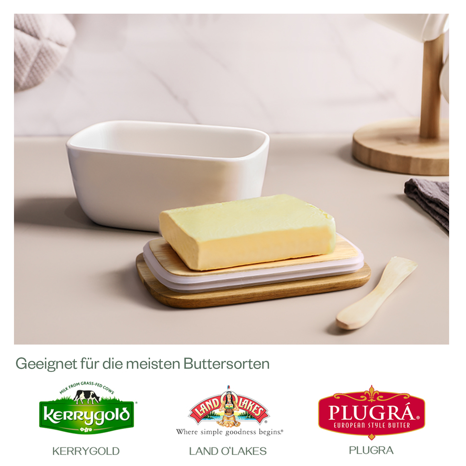 Una burriera con burro. Il burro è su un vassoio di legno. Ci sono tre loghi di marca: Kerrygold, Land O'Lakes e Plugra.