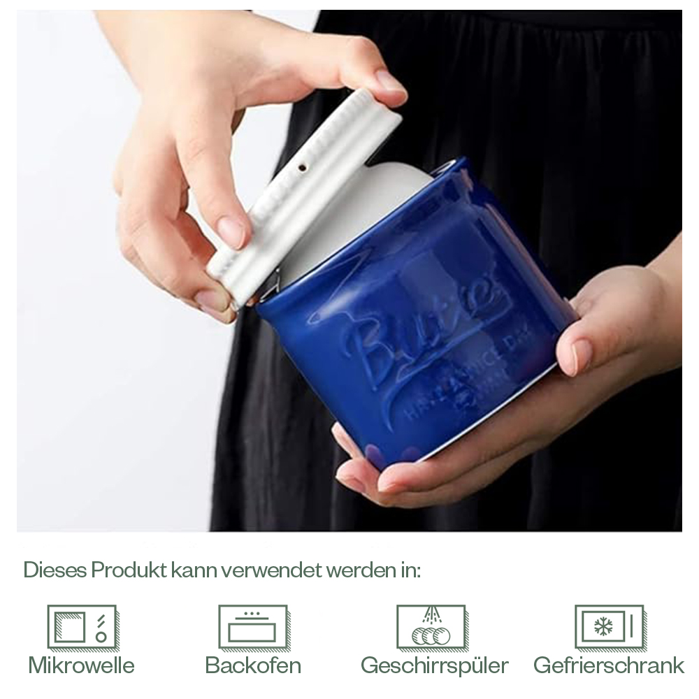Eine Person öffnet eine blaue Butterdose. Auf der Dose steht das Wort 'Butter'.