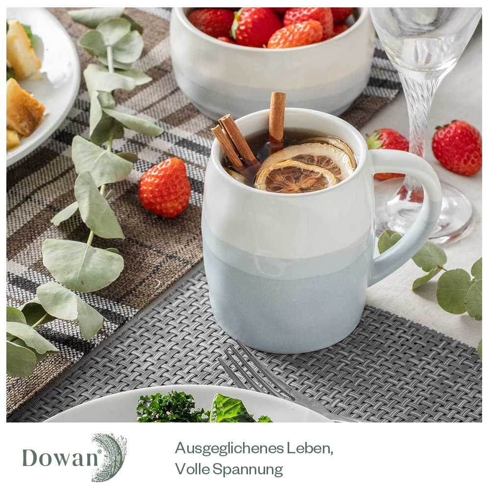 Una tazza con un design blu e bianco con cannella e limone, accanto alle fragole.