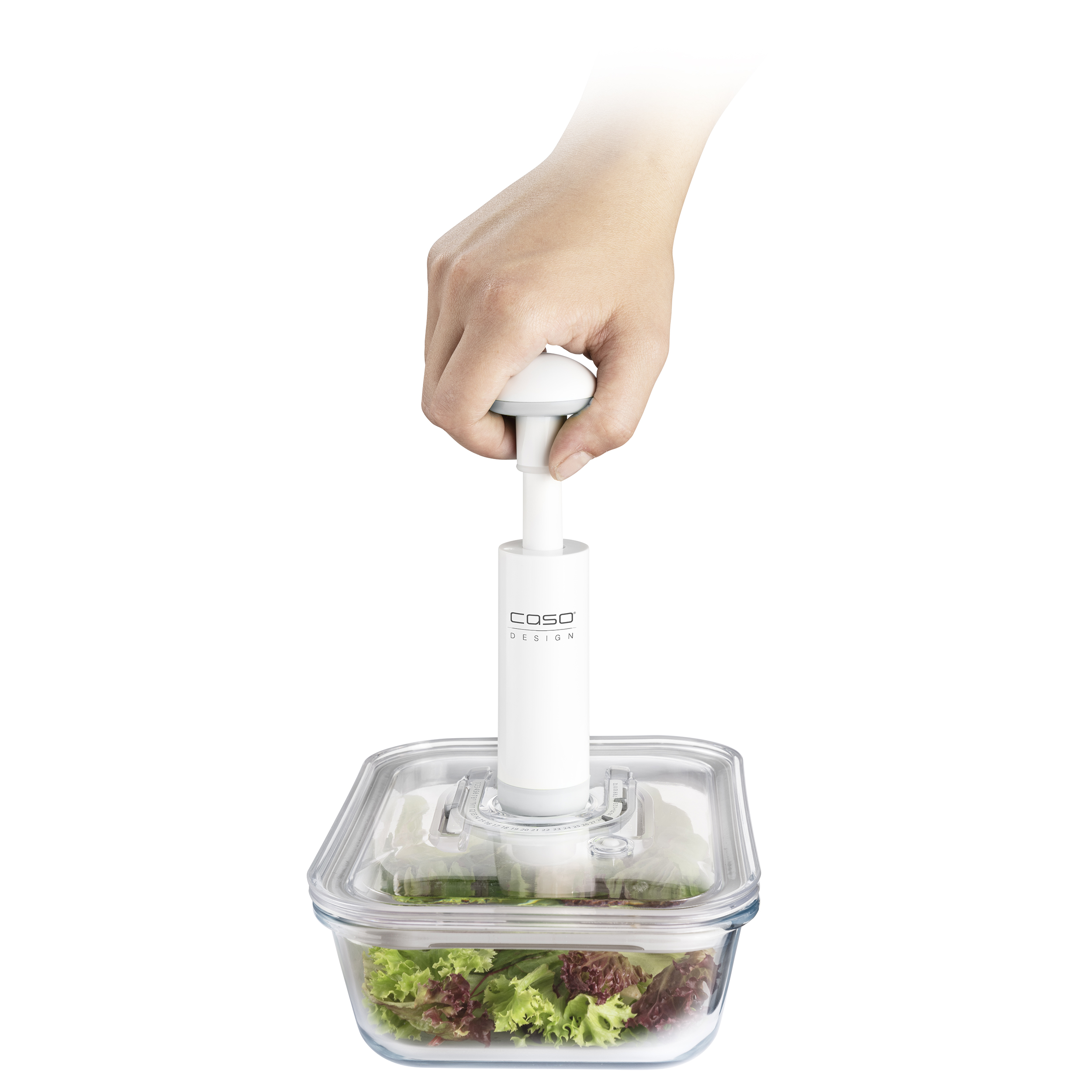 Eine Hand hält eine weiße Vakuumpumpe über einem Glasbehälter mit Salat.