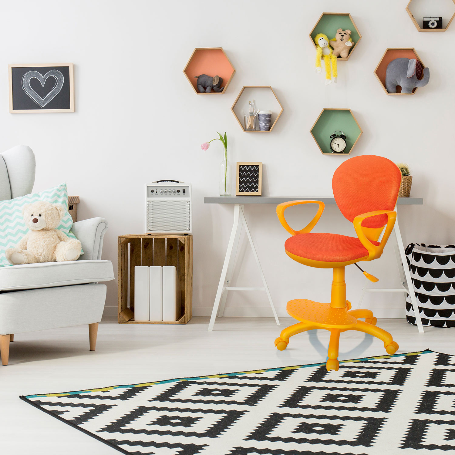 Orangener Bürostuhl in einem Kinderzimmer mit Bär, Tafel und dekorativen Regalen.