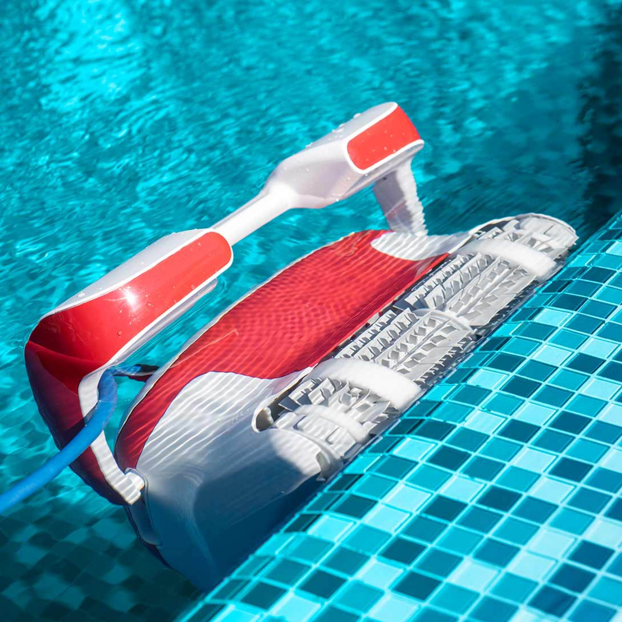 Un limpiafondos sumergido en una piscina. El limpiador es rojo y blanco con una manguera azul.