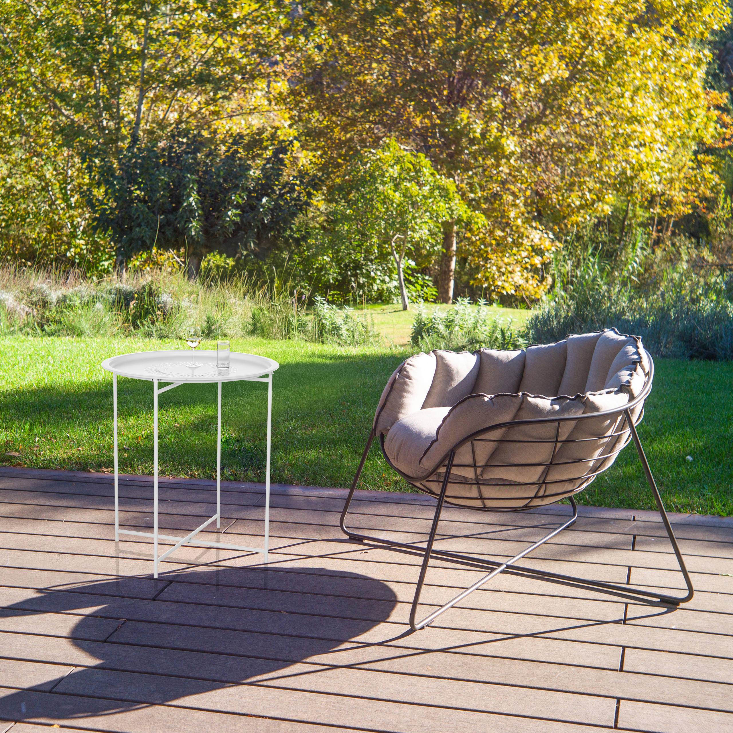 Outdoor-Szene mit einem grauen Stuhl und einem weißen Beistelltisch auf einem Holzdeck.