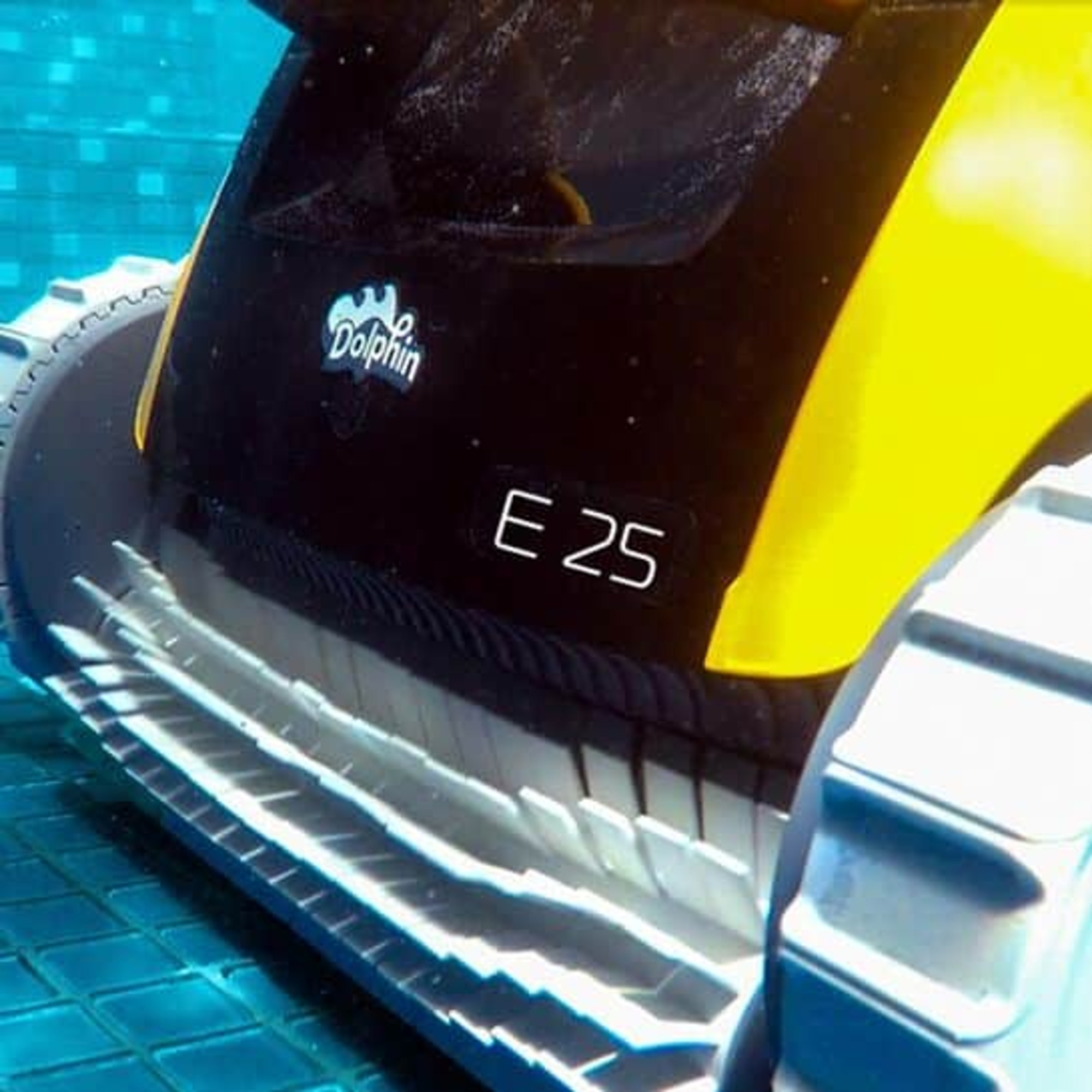 Un robot limpiador de piscinas, primer plano. La máquina es negra y amarilla.