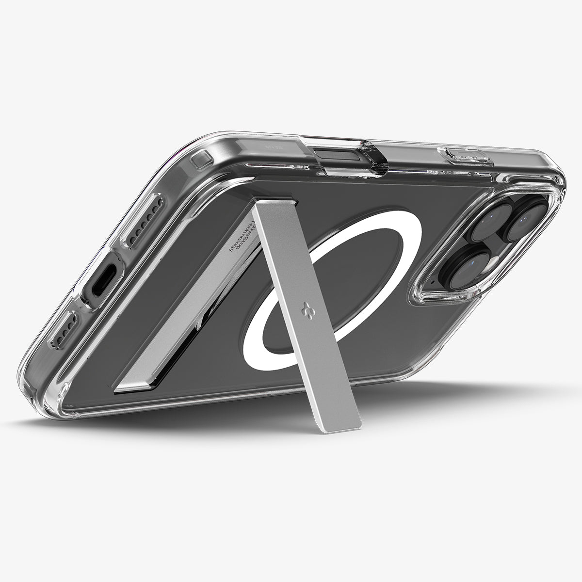Een doorzichtige telefoonhoes met een telefoon erin. Er is een witte MagSafe-cirkel en een zilveren standaard.