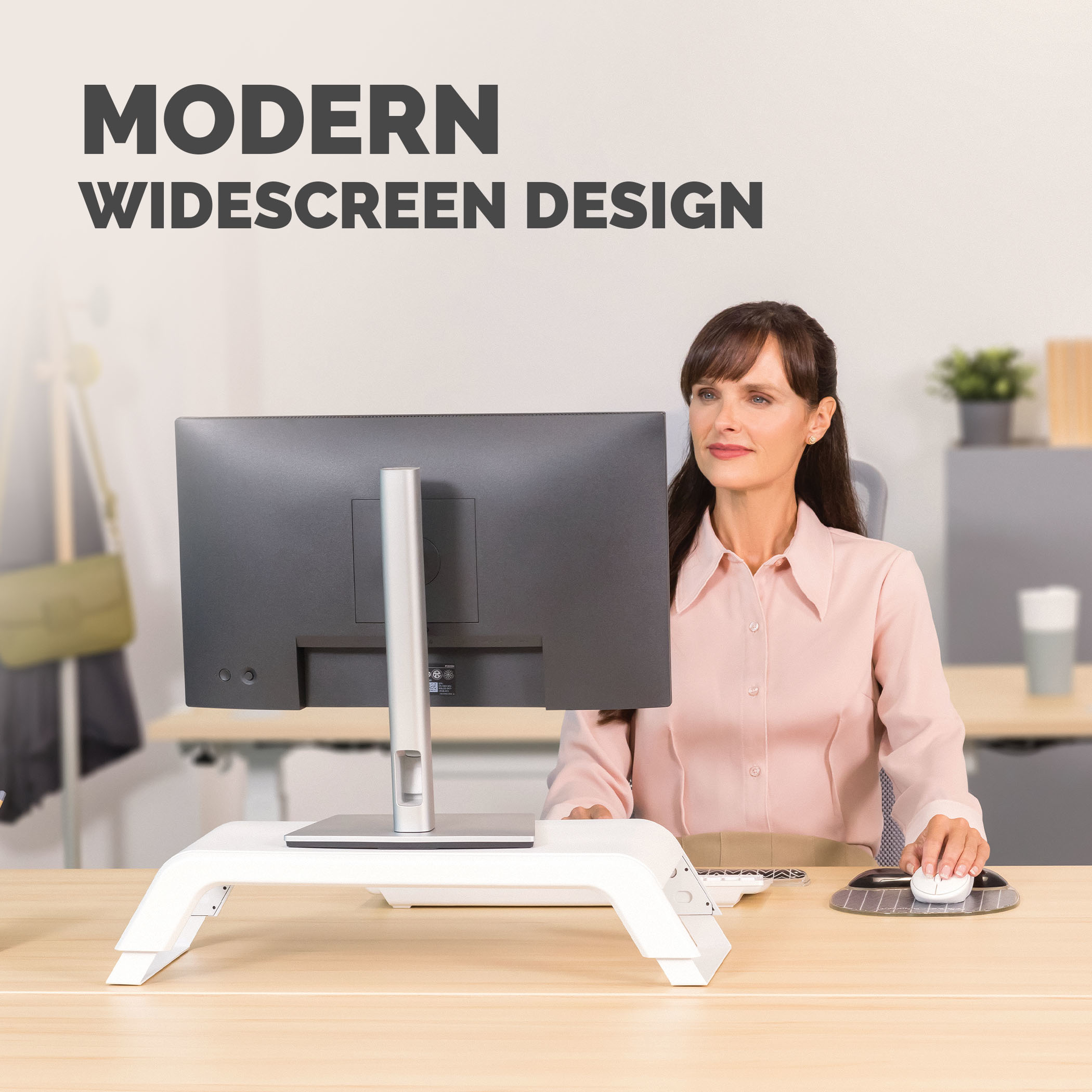 Frau am Schreibtisch, Monitor auf weißem Ständer. Maus auf Mauspad. Text 'Modernes Breitbild-Design' oben.