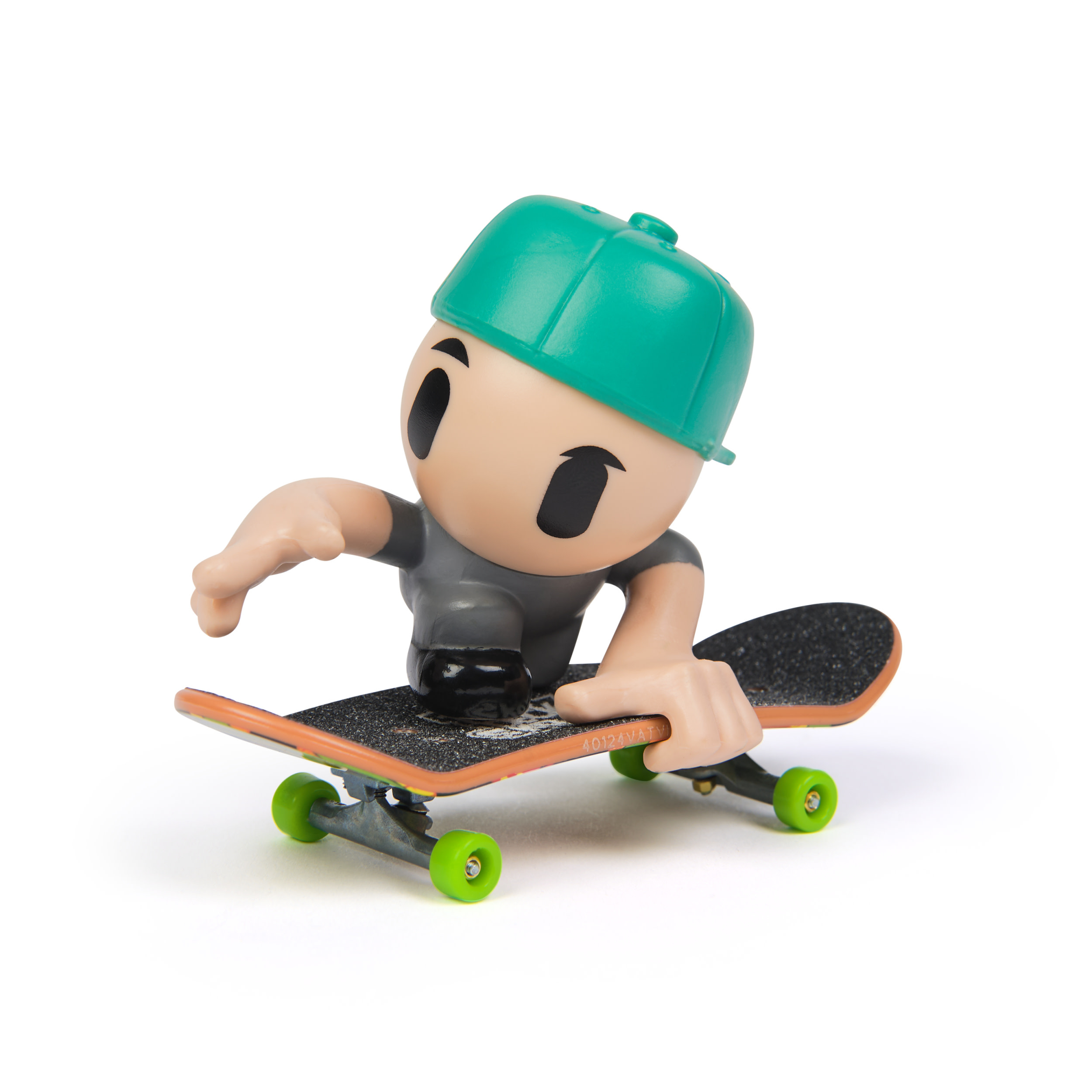 Una pequeña figura de juguete de un skater con gorra verde en un monopatín, aislado.