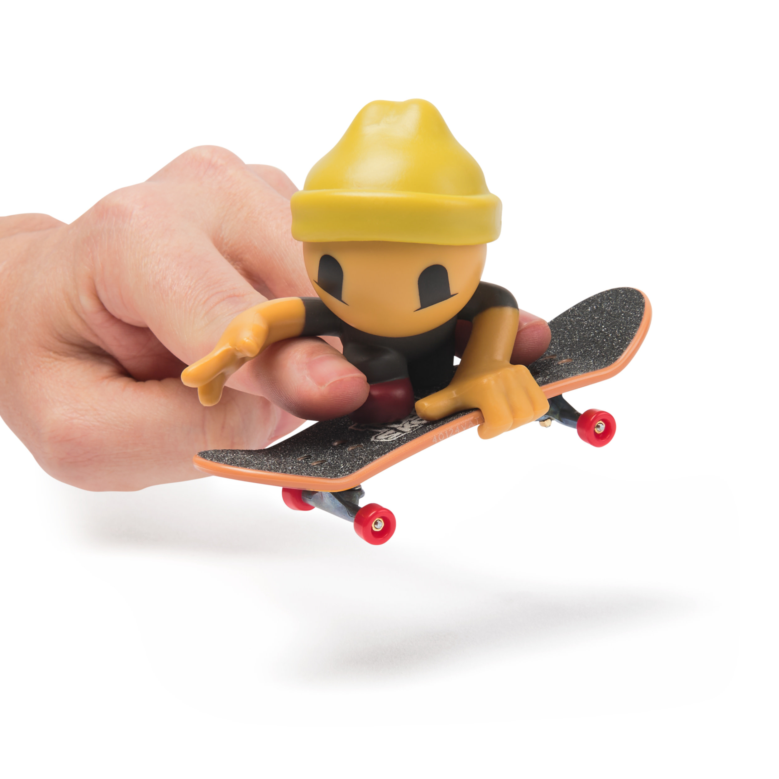 Una mano sosteniendo un pequeño monopatín con una figura de skater, aislado.