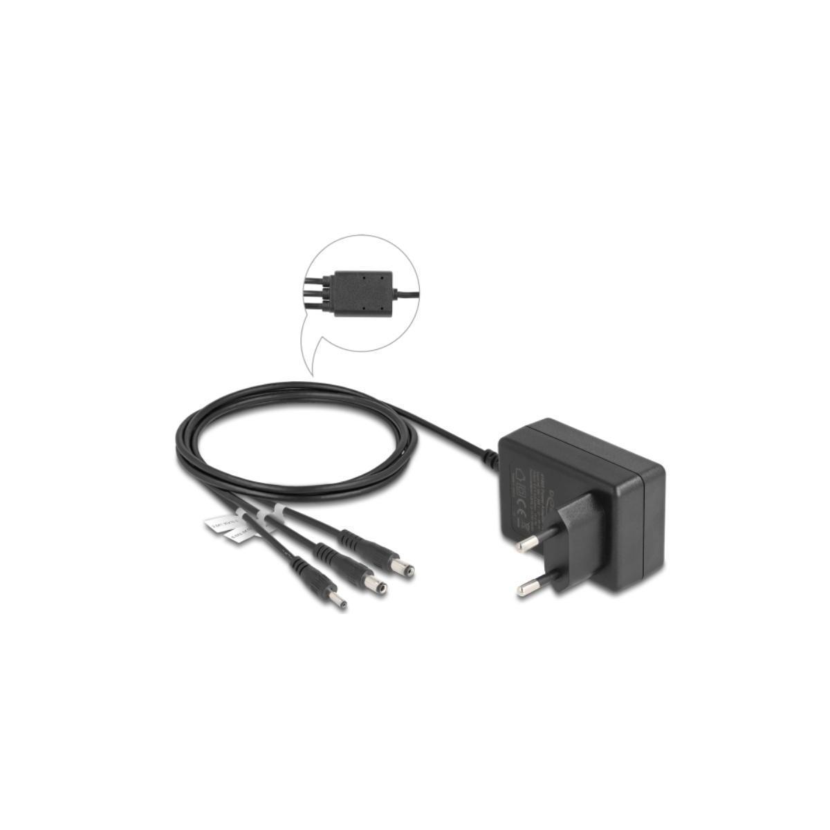 Ein schwarzes Netzteil mit mehreren DC-Anschlüssen und einem runden Kabel. Ein kleiner Einsatz ist vorhanden.