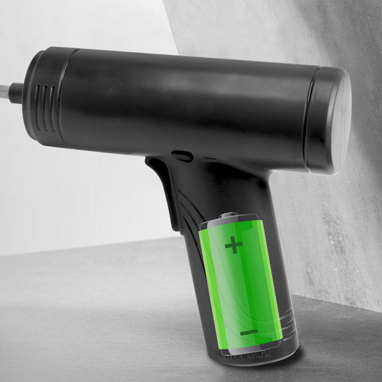 Ein schwarzes Werkzeug mit einem grünen Batteriesymbol. Das Werkzeug wird schräg vor einer grauen Oberfläche gehalten.