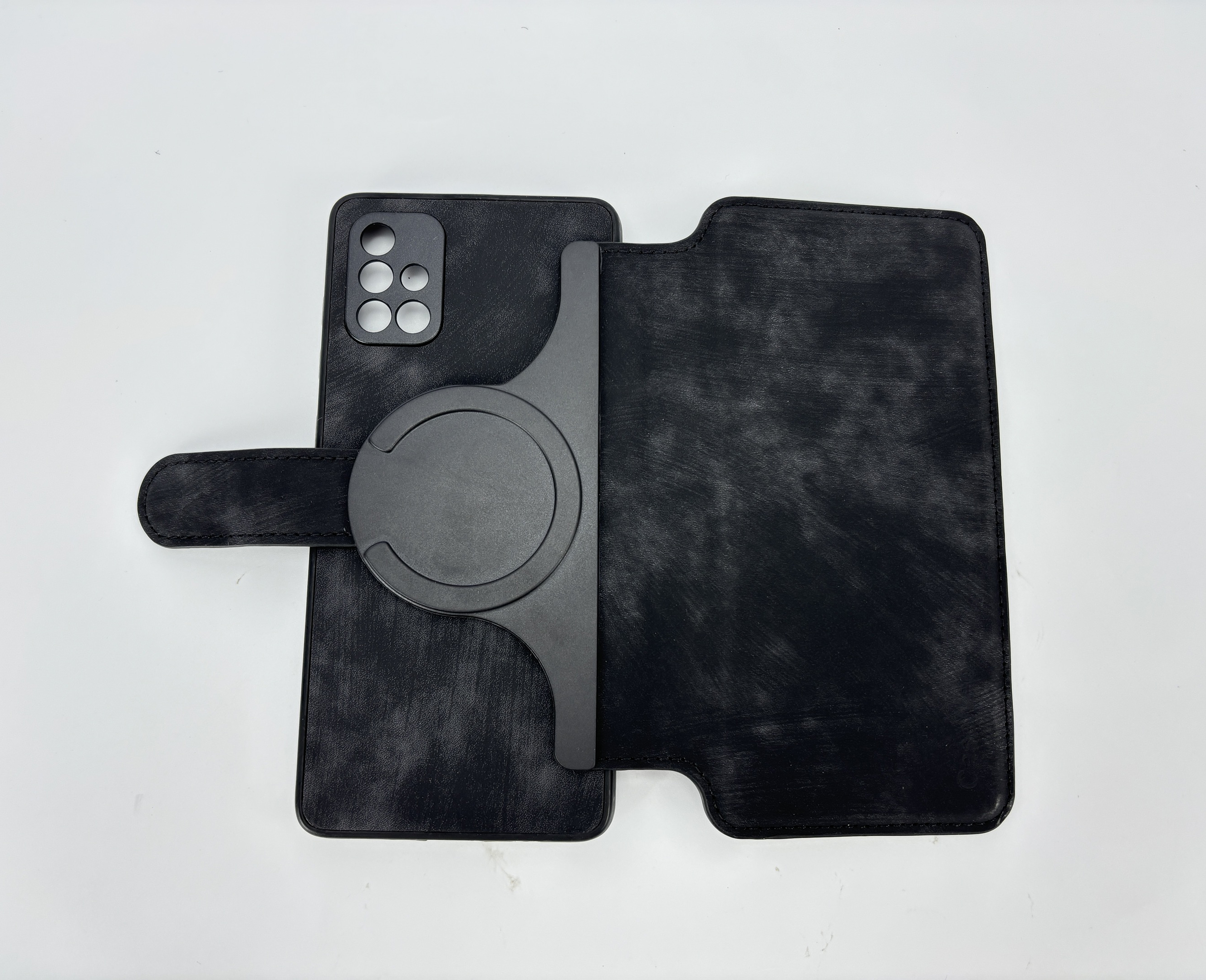 Geöffnete schwarze Handyhülle mit Telefonumriss und kreisförmigem Magnetaufsatz.