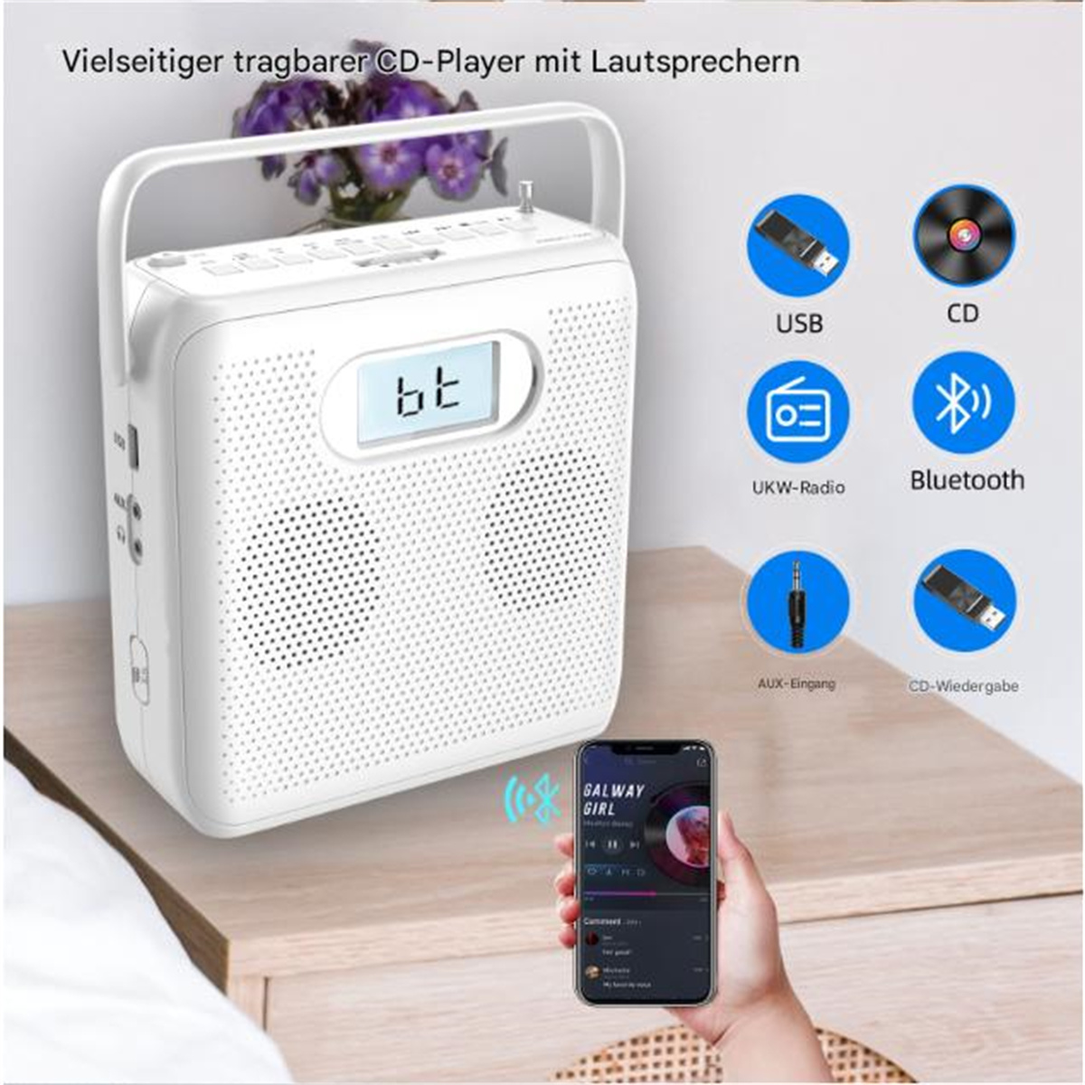 Ein weißes Radio auf einer Holzoberfläche. Es hat einen Griff, Knöpfe und eine Digitalanzeige mit '102.5'.