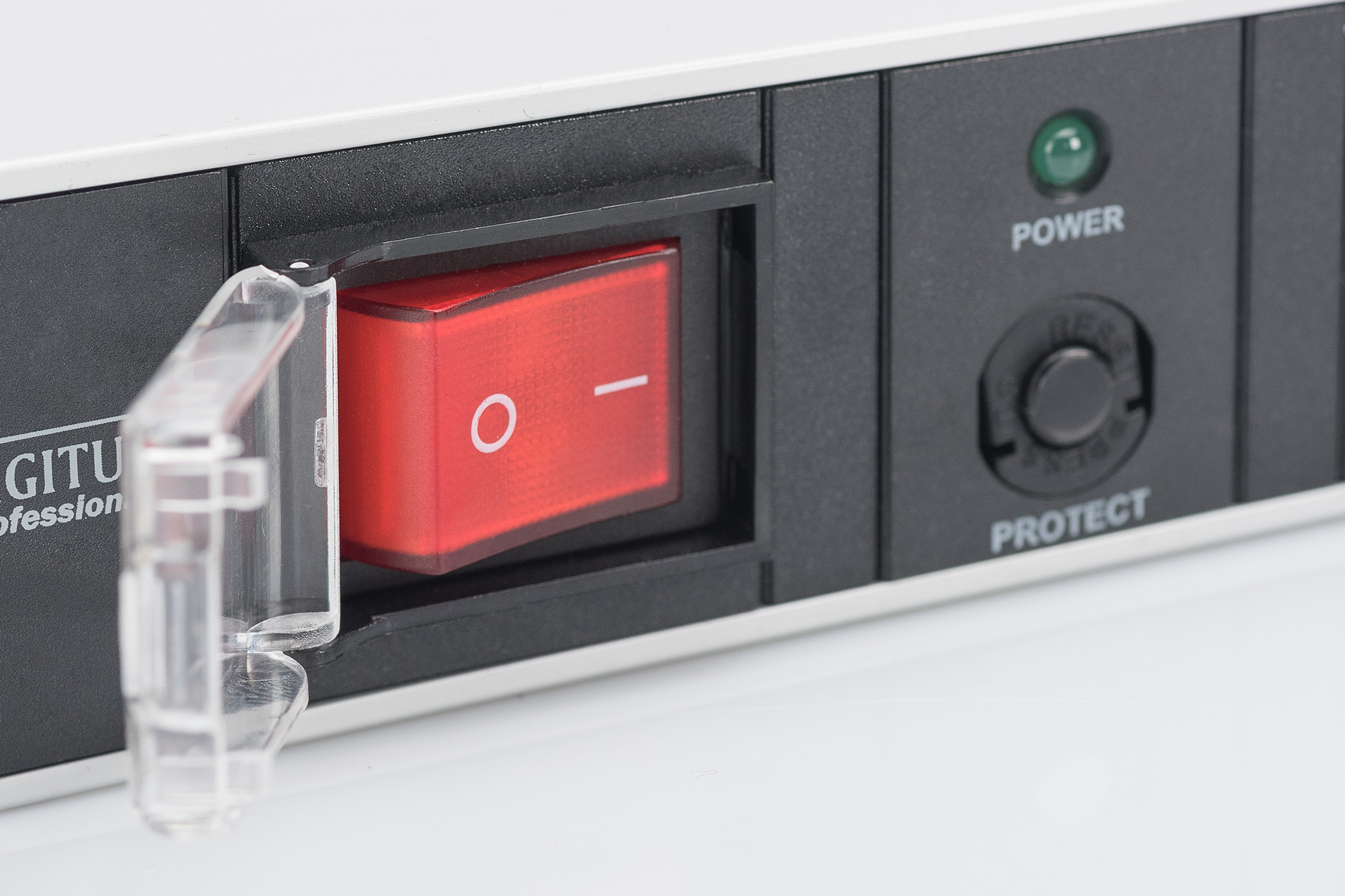 Primo piano dell'interruttore di una multipresa con interruttore rosso e coperchio trasparente, pulsanti power e protect.