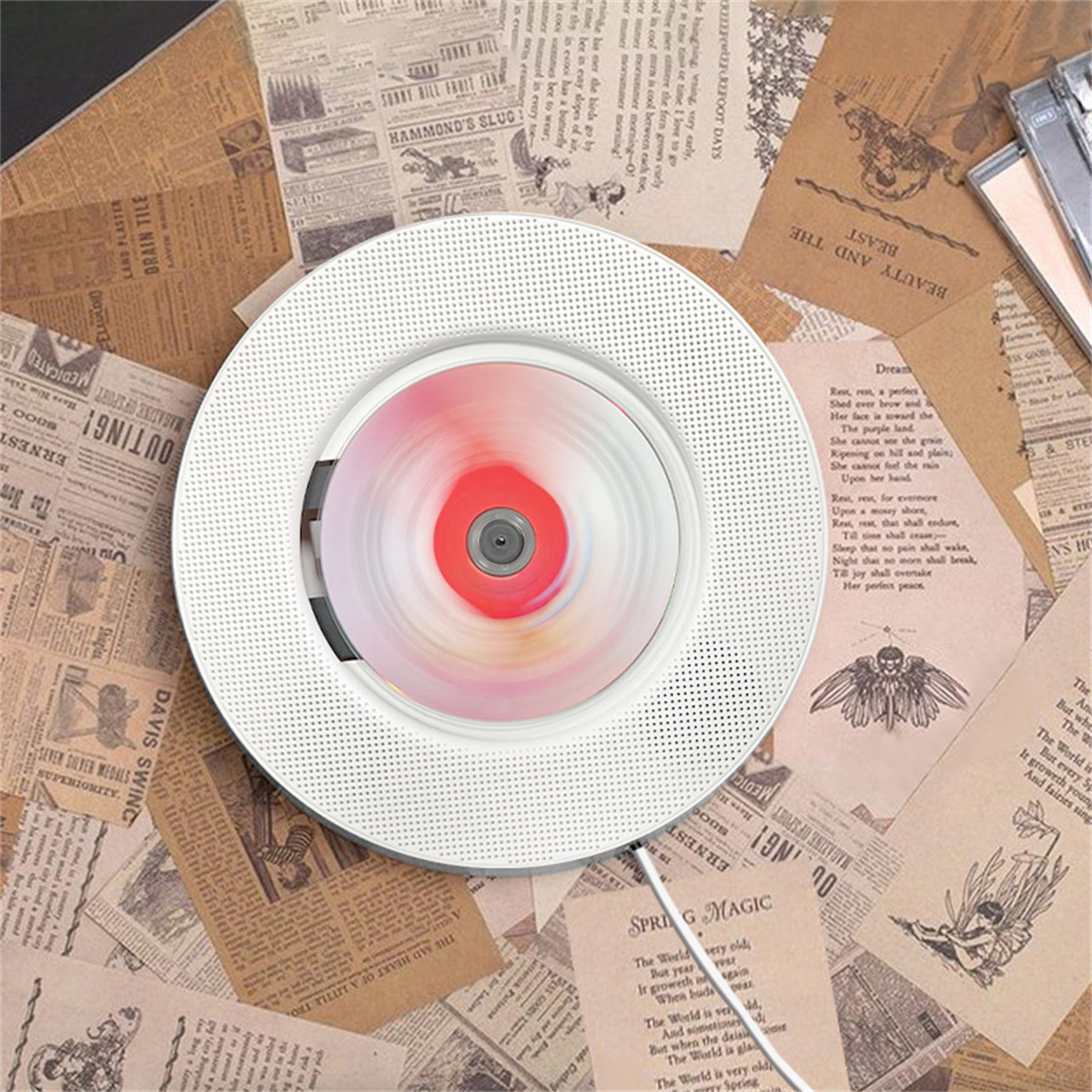 Weißer CD-Player auf Papierhintergrund. Die sich drehende CD in der Mitte ist rosa. Text und Zeichnungen sichtbar.