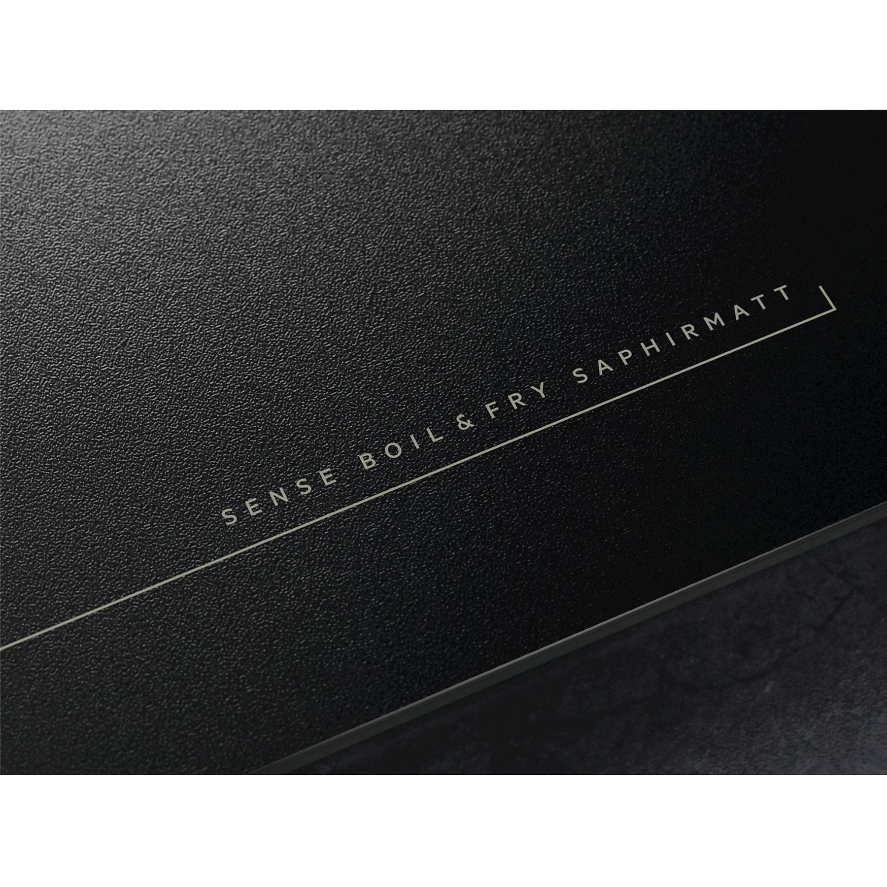 Czarna powierzchnia z białym tekstem 'SENSE BOIL & FRY SAPHIRMATT' i białą linią.