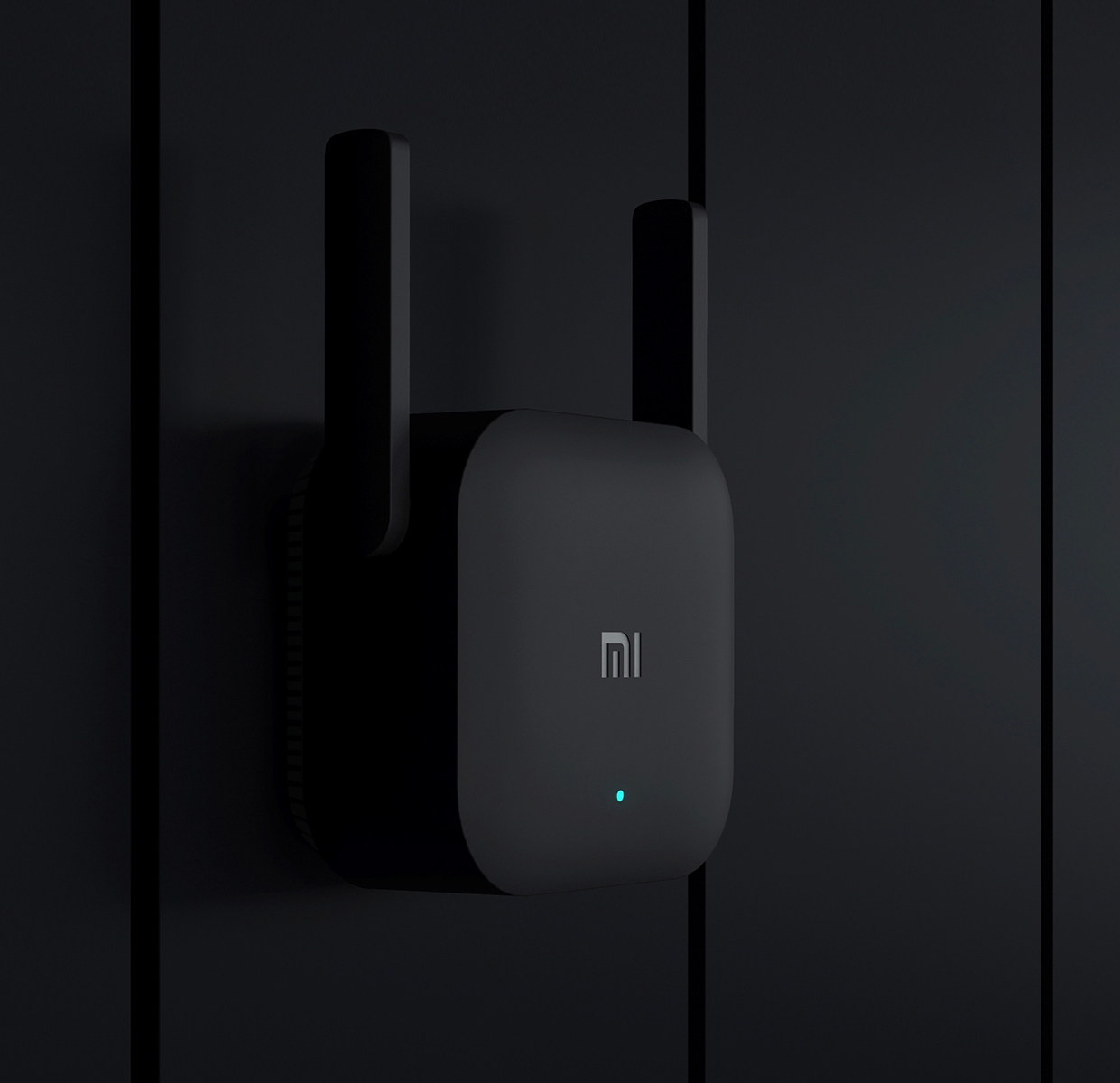 Schwarzer WLAN-Router an einer Wand. Er hat zwei Antennen und ein blaues Licht.
