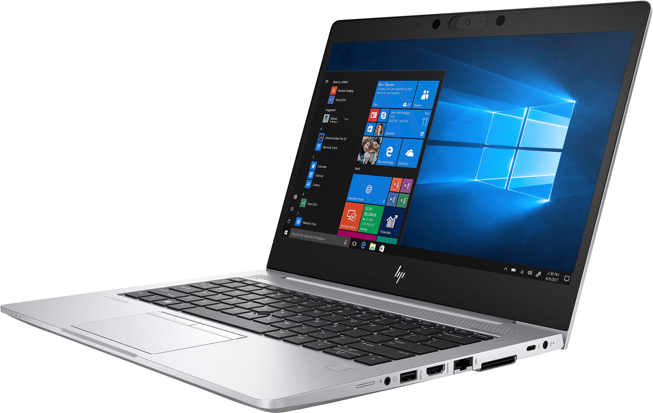 A silver laptop is open on a desk, displaying the Windows desktop. The screen is blue.
