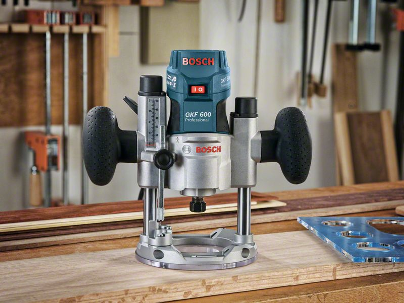 Professioneller Bosch GKF 600 Router auf Holz. Verschiedene Werkzeuge und Holz im Hintergrund.