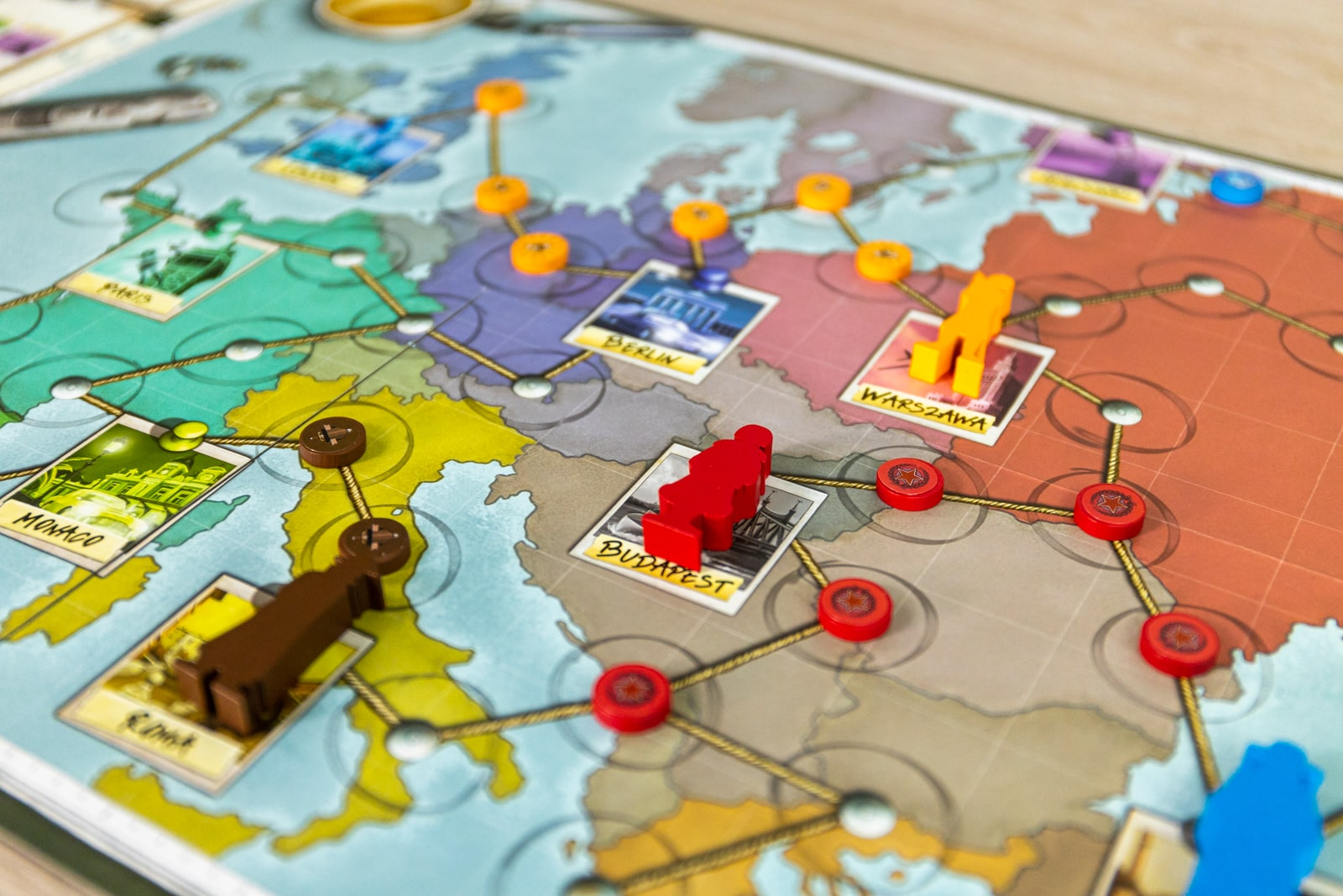 Brettspiel mit Figuren auf einer Karte, die Städte und Routen zeigt.