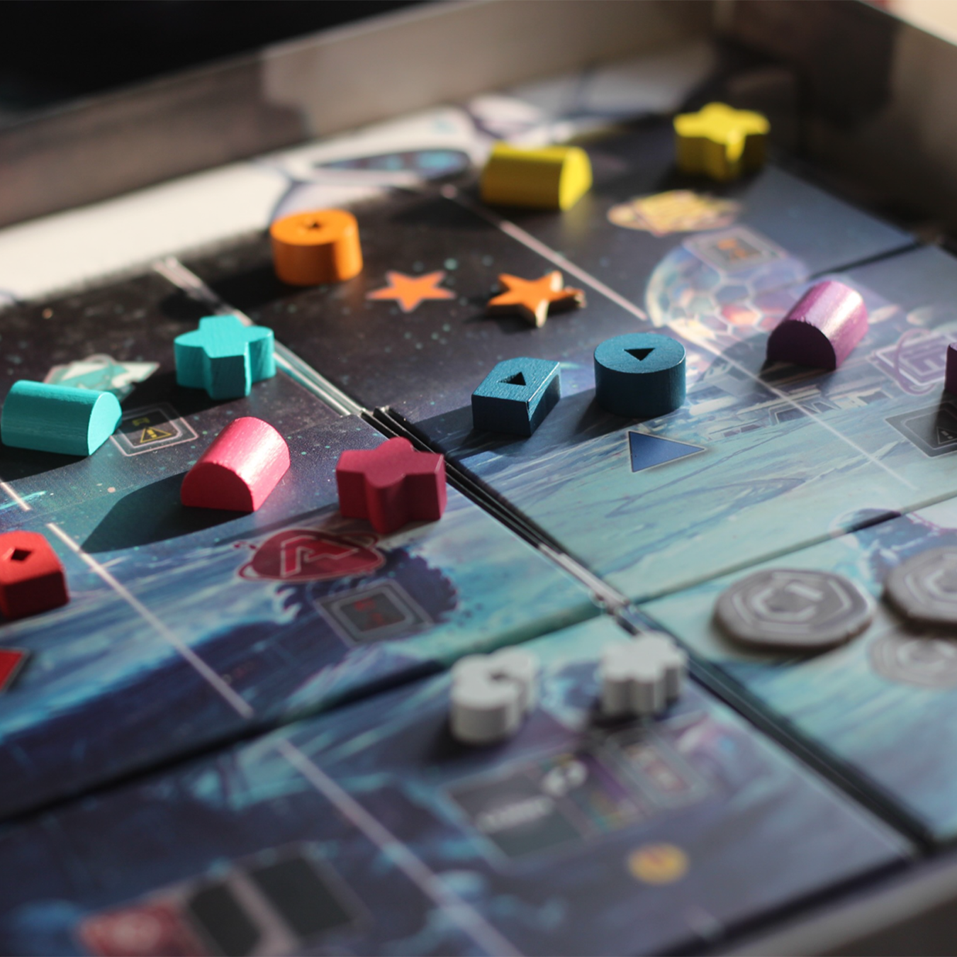 Brettspiel im Spiel. Holzstücke in verschiedenen Farben auf einem blauen Spielbrett mit Sternen.