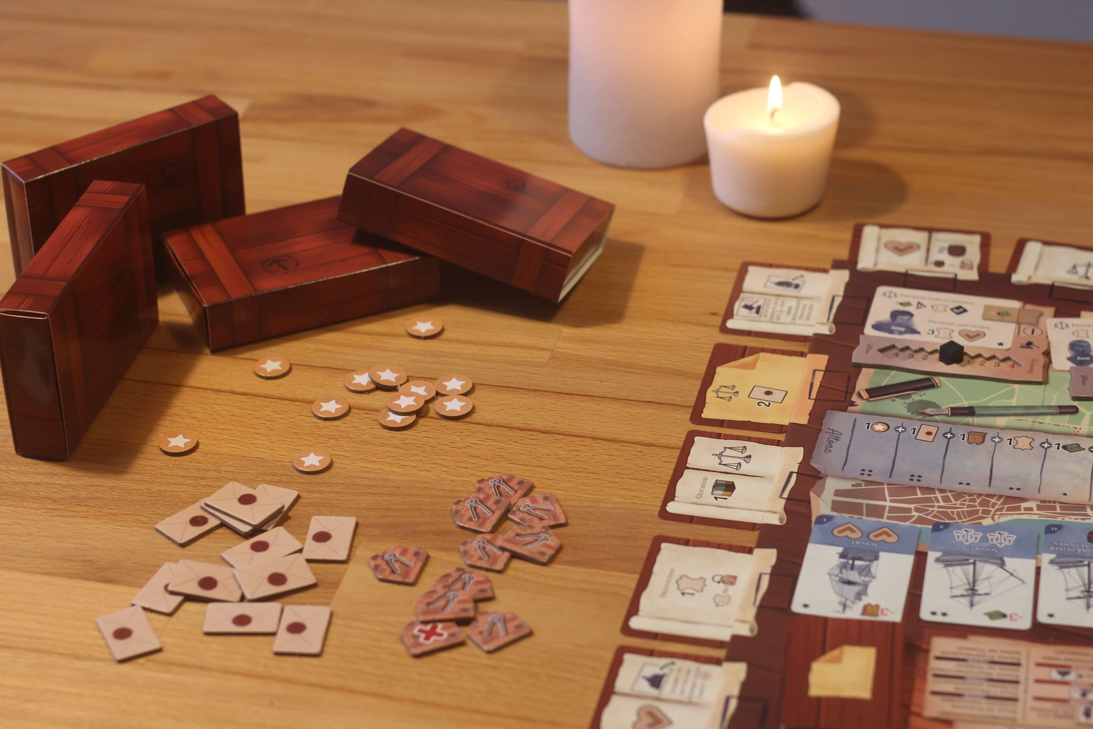 Configurazione del gioco da tavolo. Scatole di legno, candele e pezzi del gioco sono disposti su un tavolo.