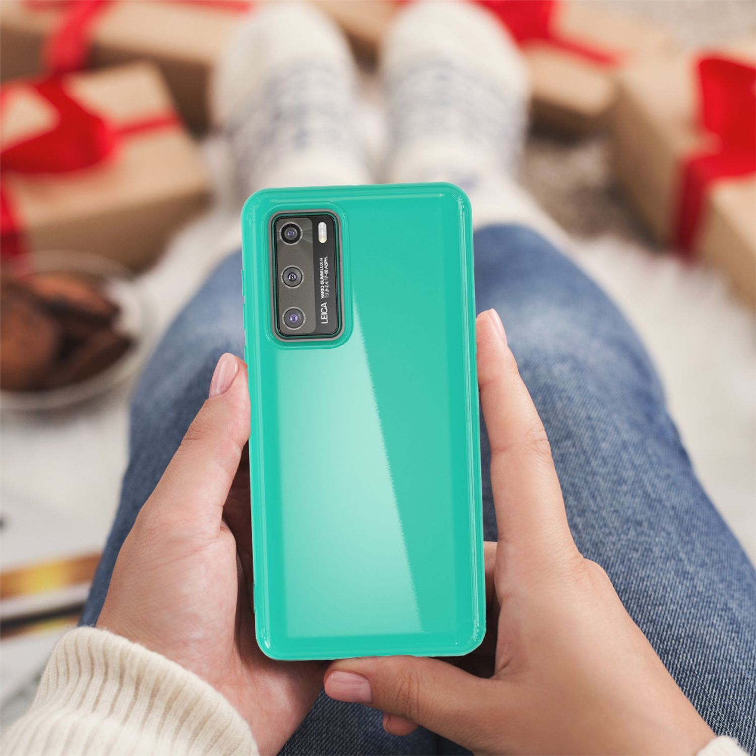 Person hält ein Telefon mit grüner Hülle. Die Person sitzt.