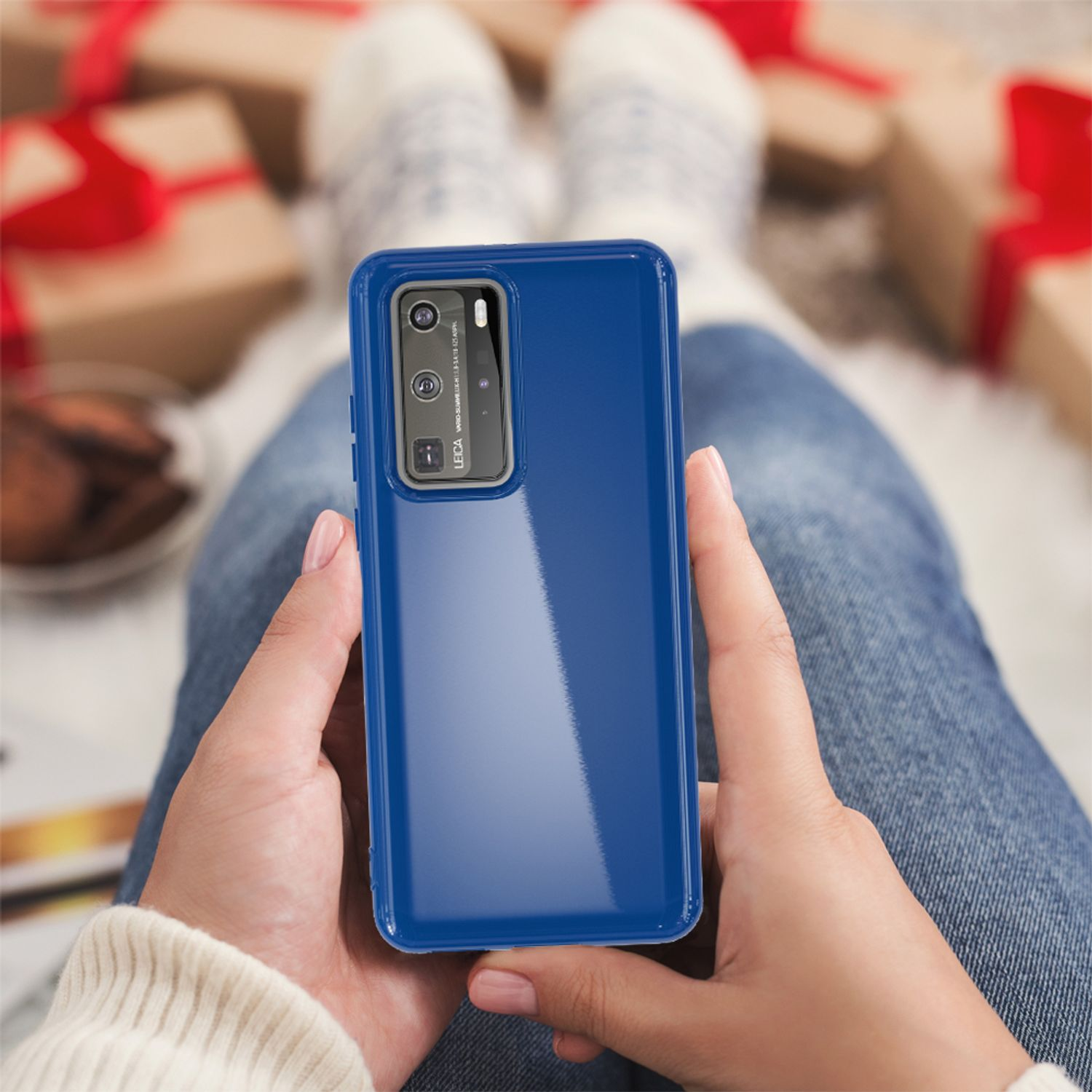 Eine Frau hält ein blaues Telefon. Die Frau sitzt mit dem Telefon in den Händen.