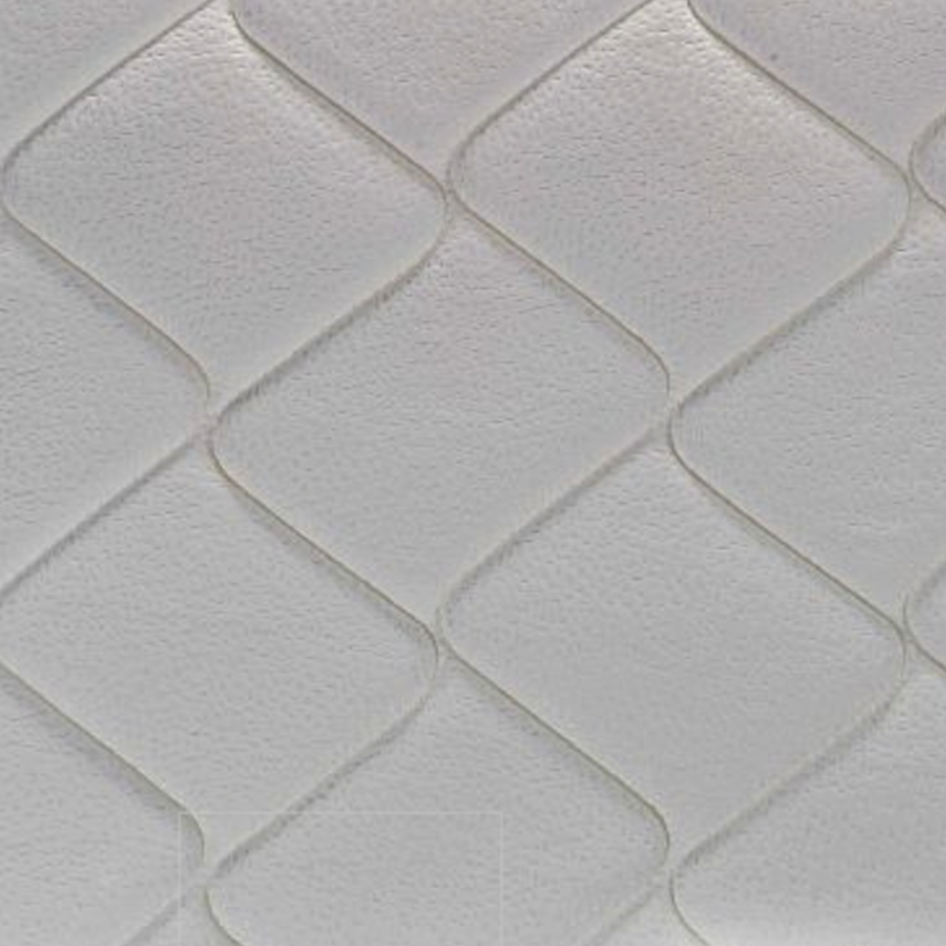 Primer plano de un colchón blanco con un patrón de diamantes en la superficie.
