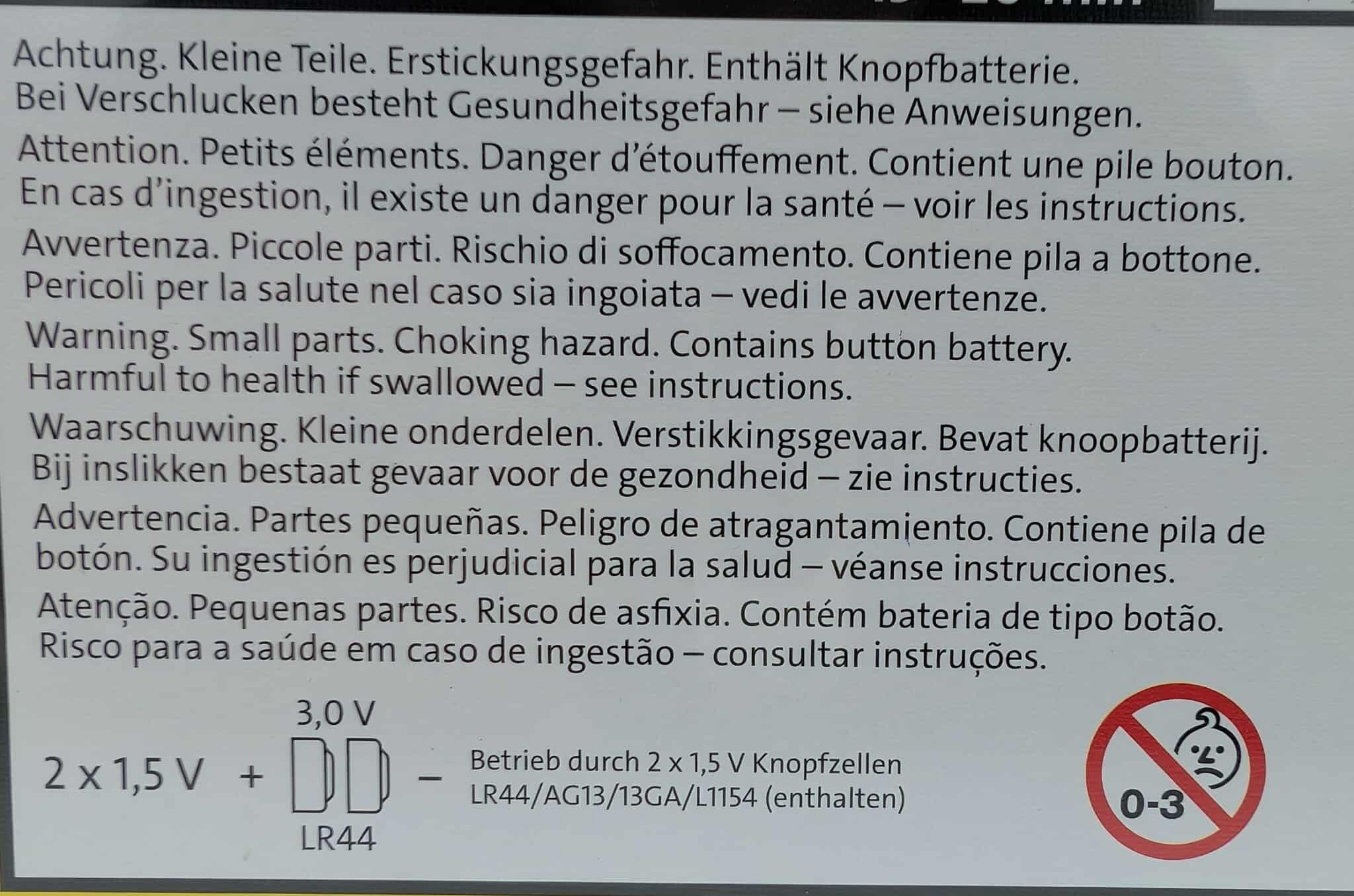 Tekst ostrzegawczy w wielu językach z grafiką ostrzeżenia i informacjami o baterii.