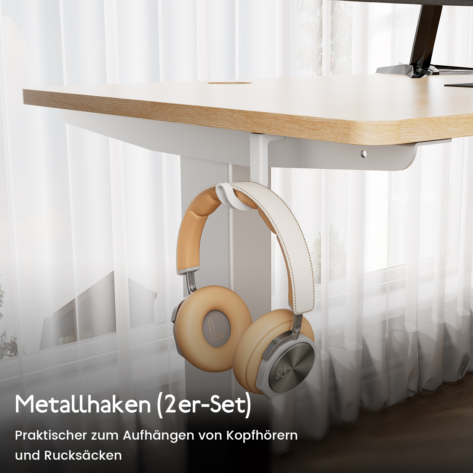 Ein Schreibtisch mit cremefarbenen und hellbraunen Kopfhörern, die an einem weißen Metallhaken hängen. Der Hintergrund zeigt ein Fenster mit weißen Vorhängen.