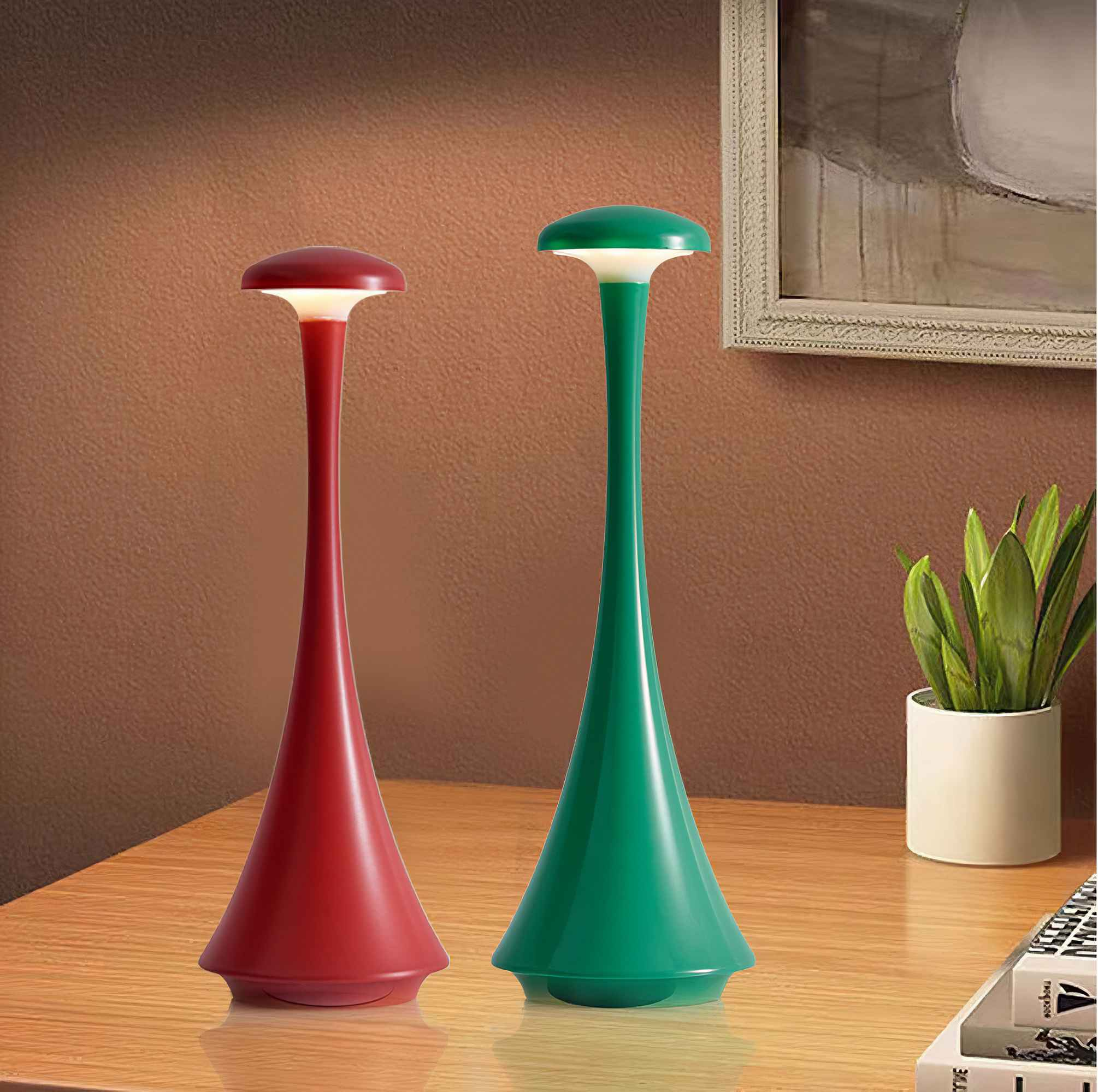 Zwei Tischlampen, rot und grün, auf einem Holztisch, mit einem Gemälde und einem weißen Topf.