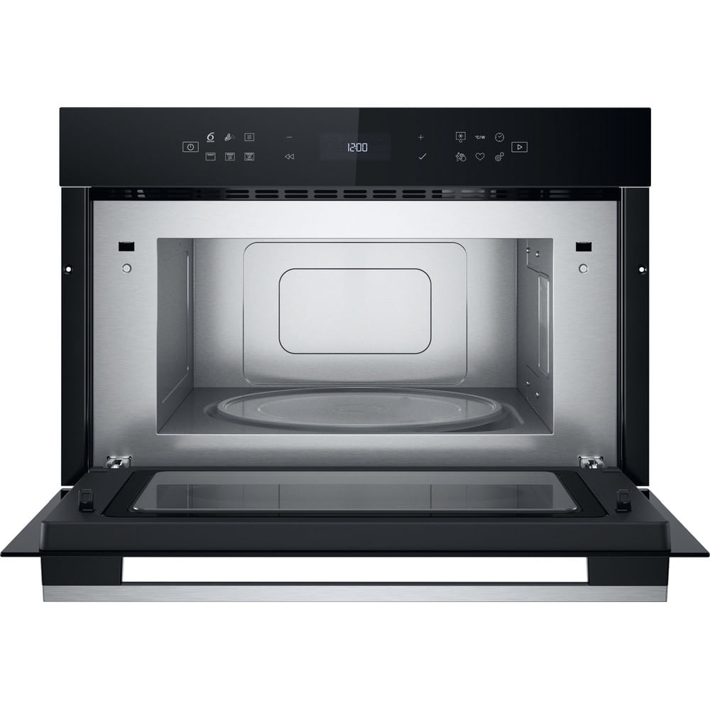 El interior de un horno microondas negro con la puerta abierta, mostrando el plato giratorio de vidrio.