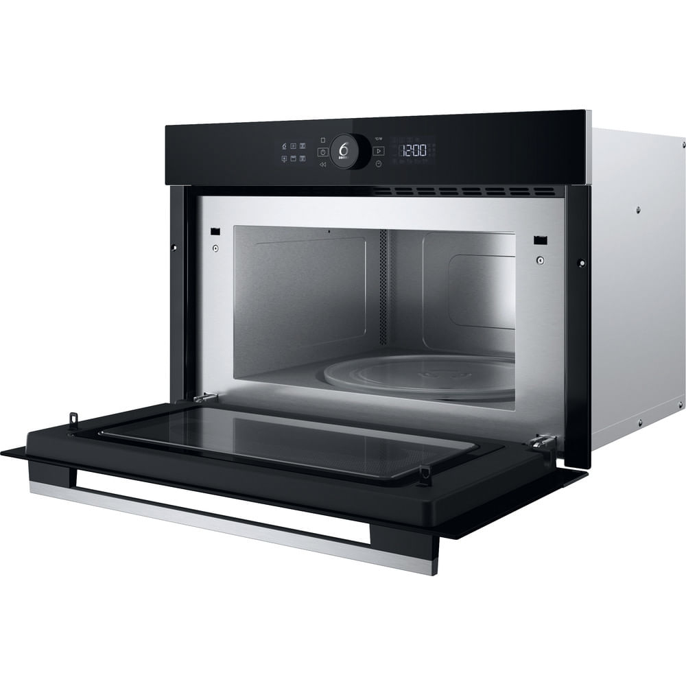 Un forno a microonde aperto con porta nera, interno argentato. Il microonde è in un mobile nero.