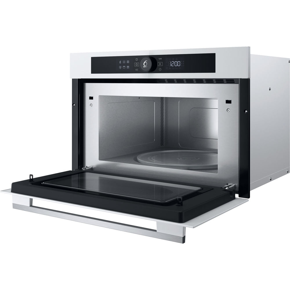 Un forno a microonde bianco con la porta aperta, l'interno è visibile. Display nero in alto.