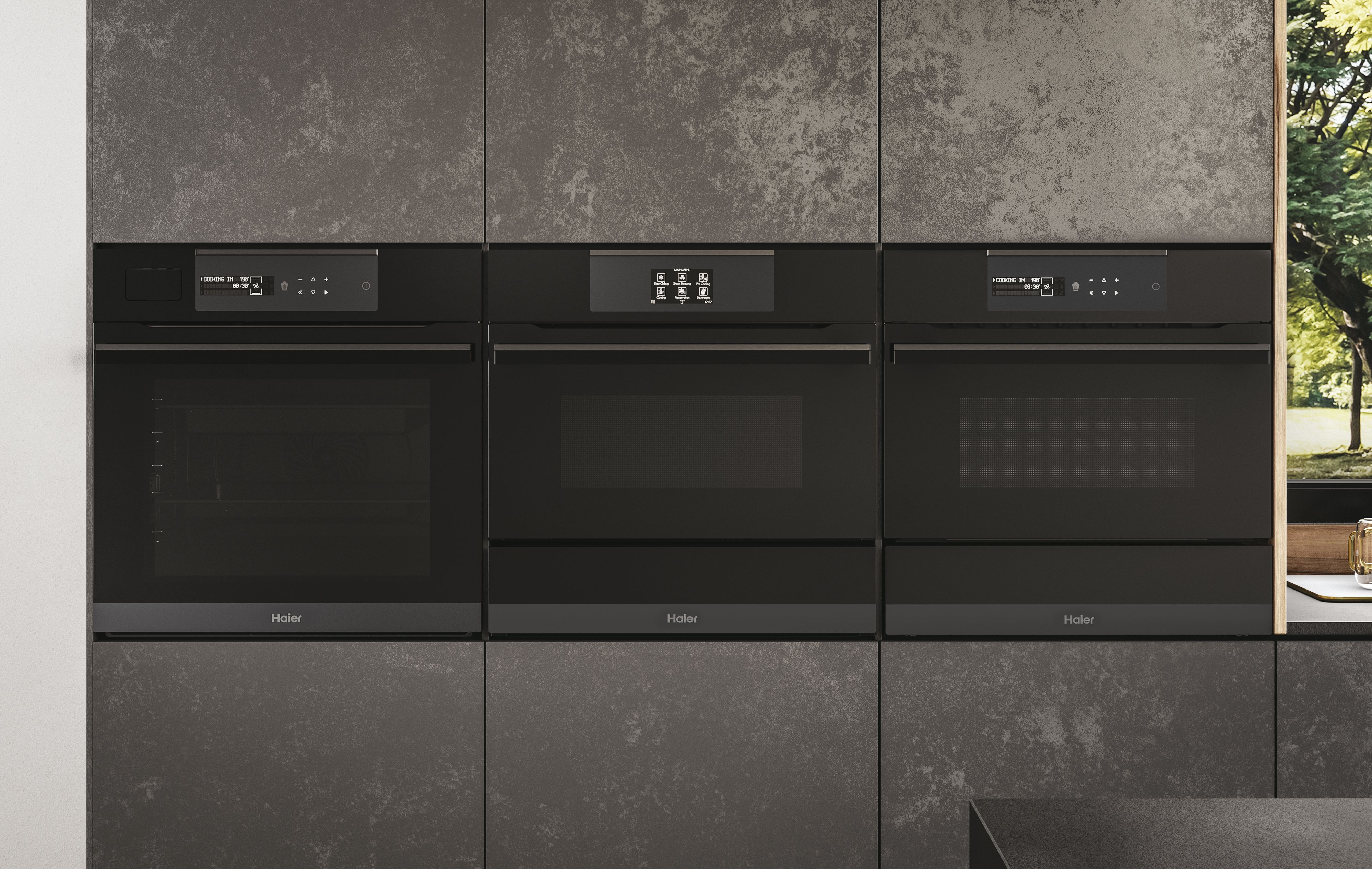 Tre forni neri a incasso uno accanto all'altro. Una cucina moderna con mobili grigio scuro.