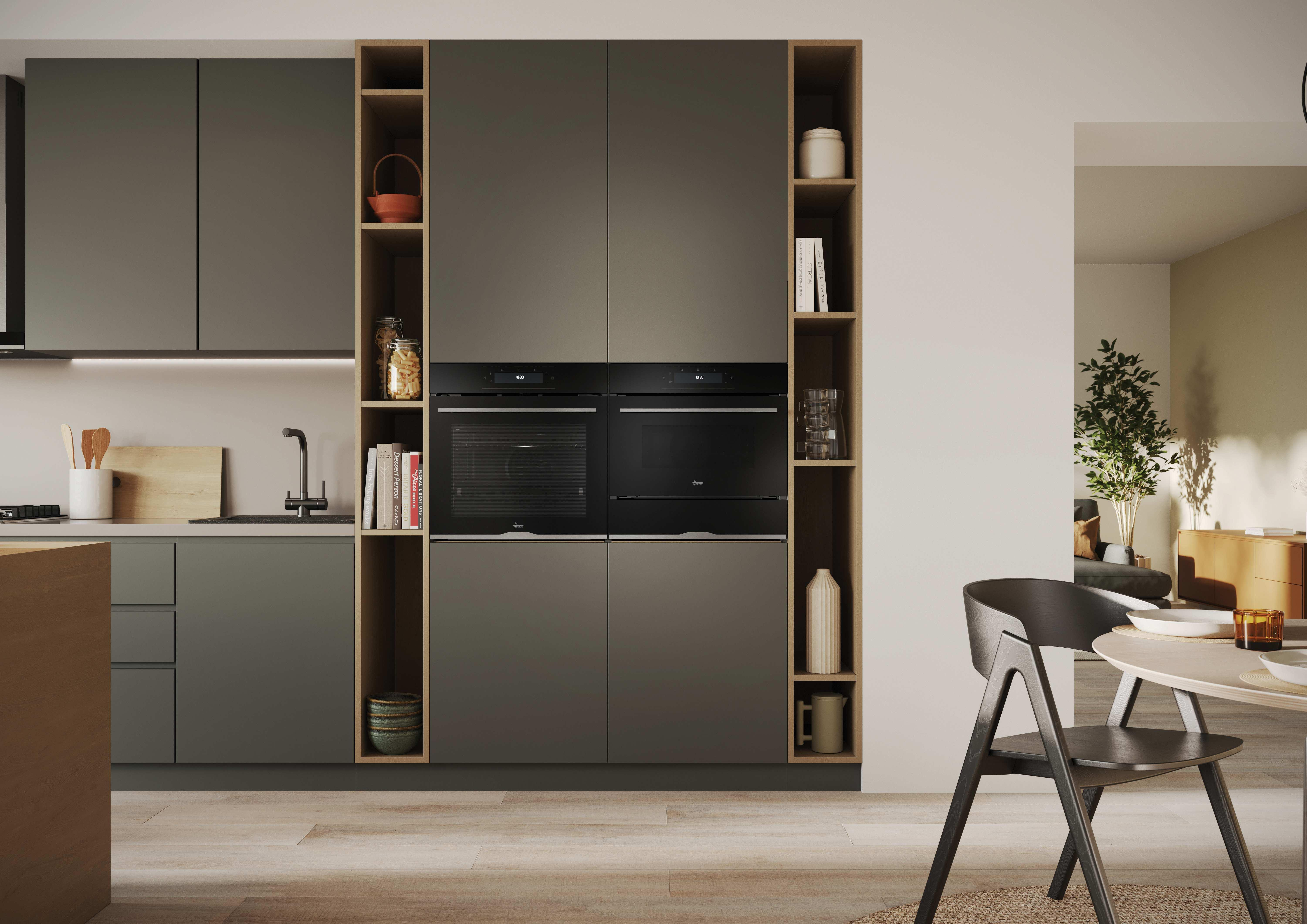 Cucina moderna con forni a incasso. Armadi in legno, mensole e decorazioni. Sala da pranzo visibile a destra.