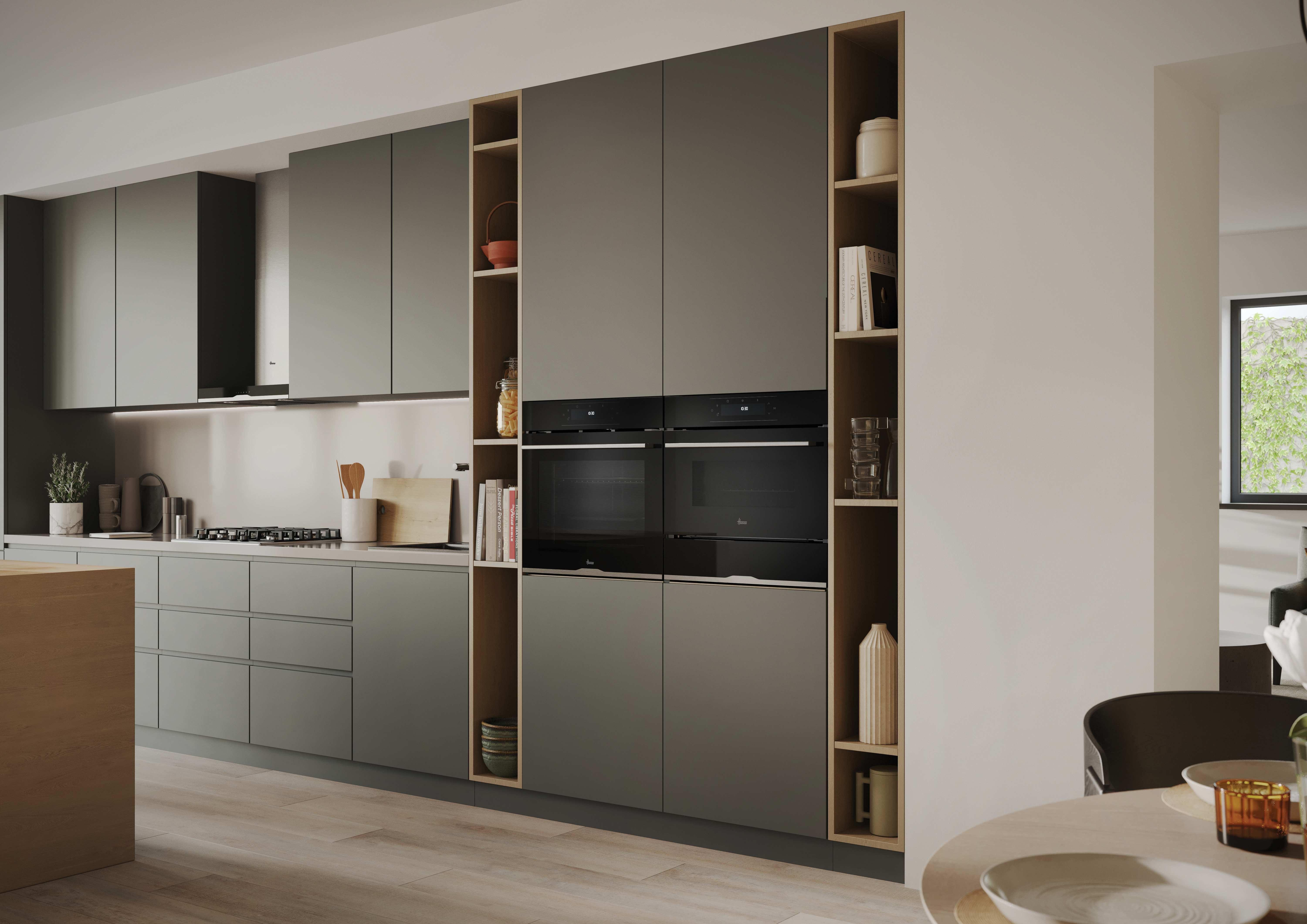Una cucina moderna con mobili grigi, forni integrati e ripiani in legno.