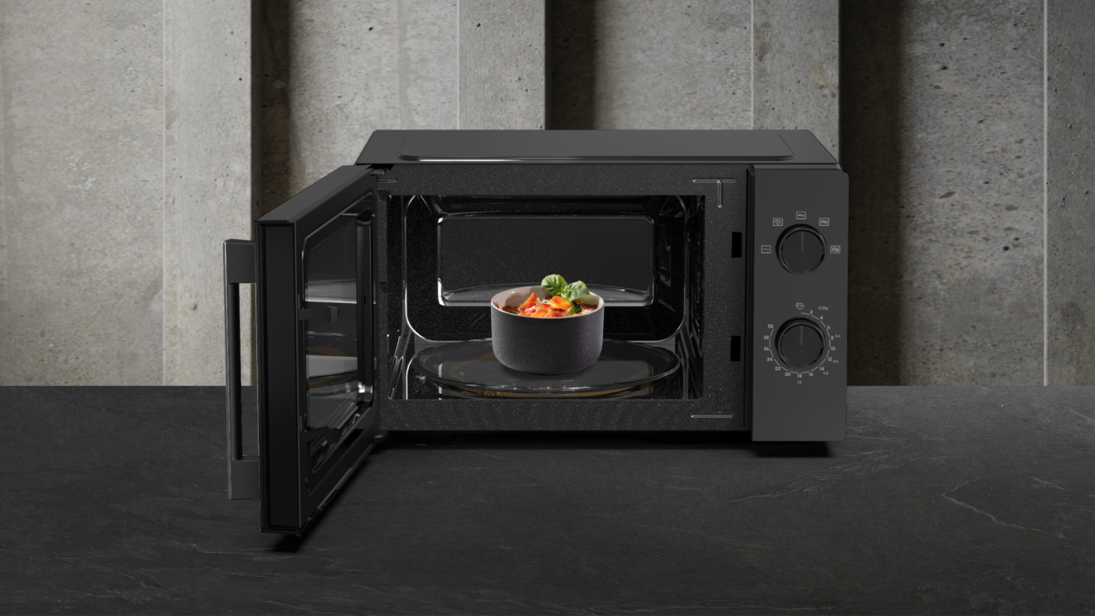 Czarna kuchenka mikrofalowa z otwartymi drzwiami, miska z jedzeniem w środku.