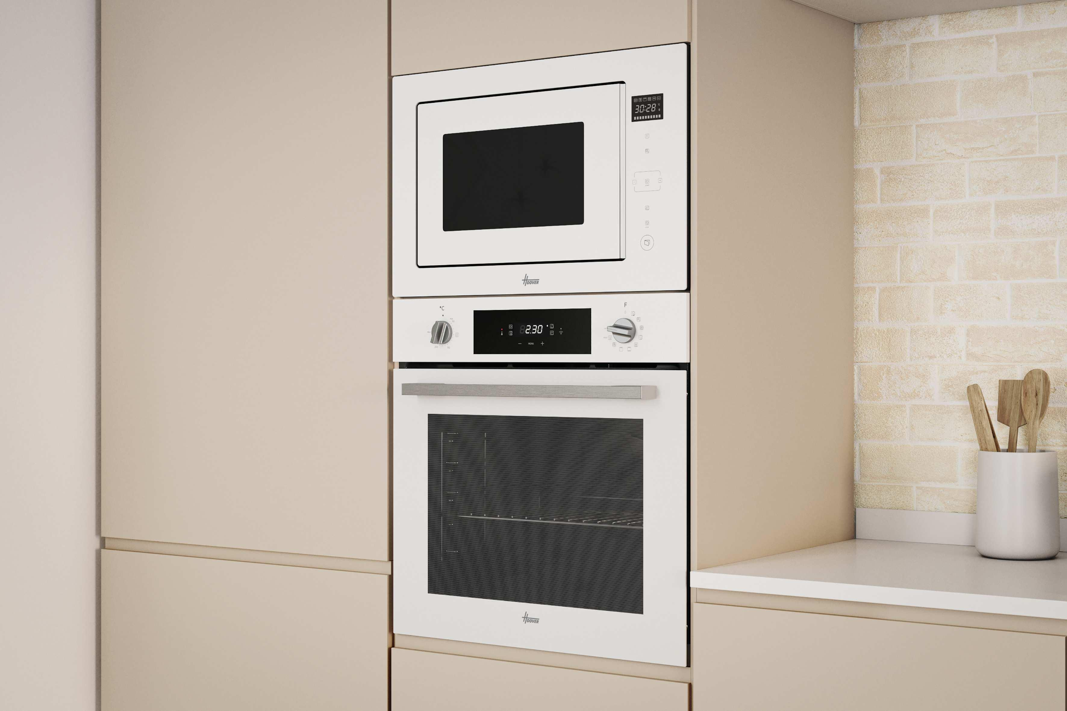 Wbudowana kuchenka mikrofalowa i piekarnik w kuchni. Białe urządzenia, beżowe szafki i ceglana ściana.