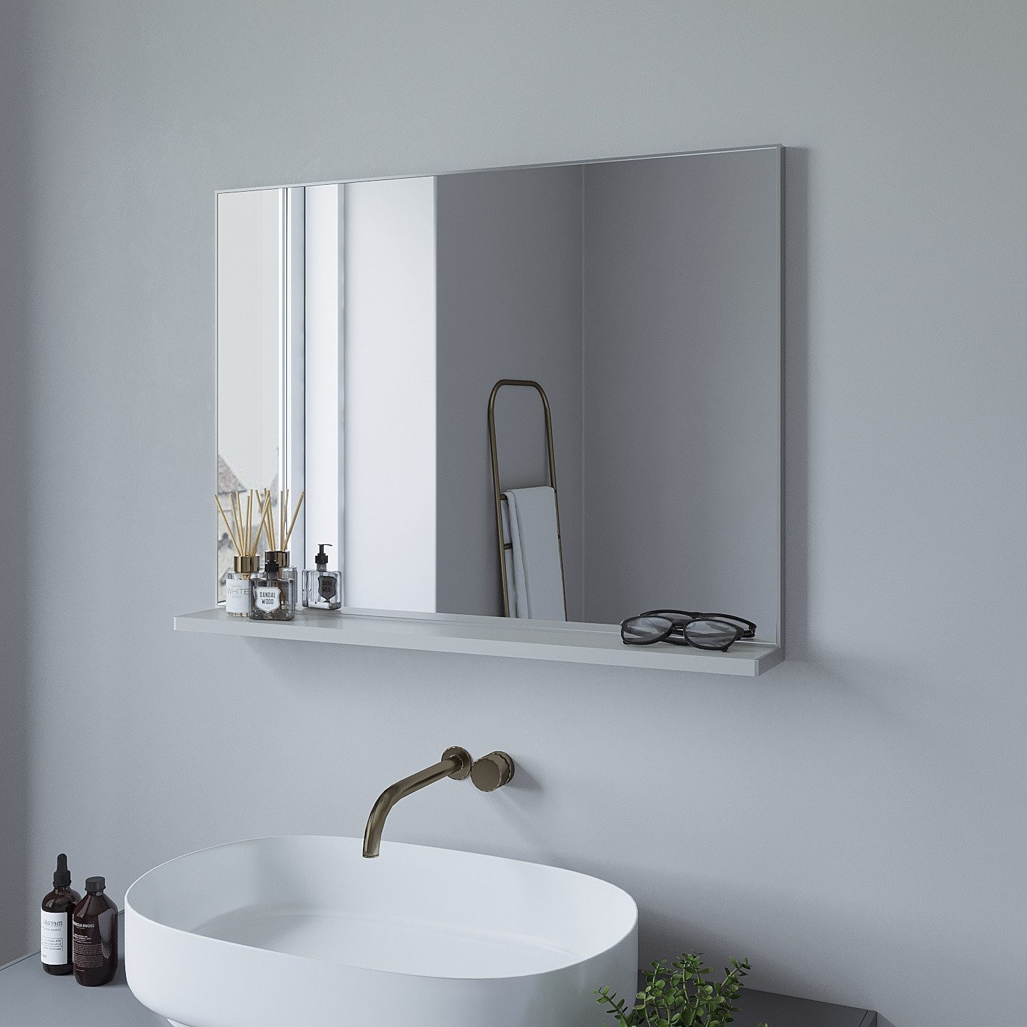 Ein Spiegel mit Ablage, Toilettenartikel, Waschbecken, Wasserhahn und graue Wand.