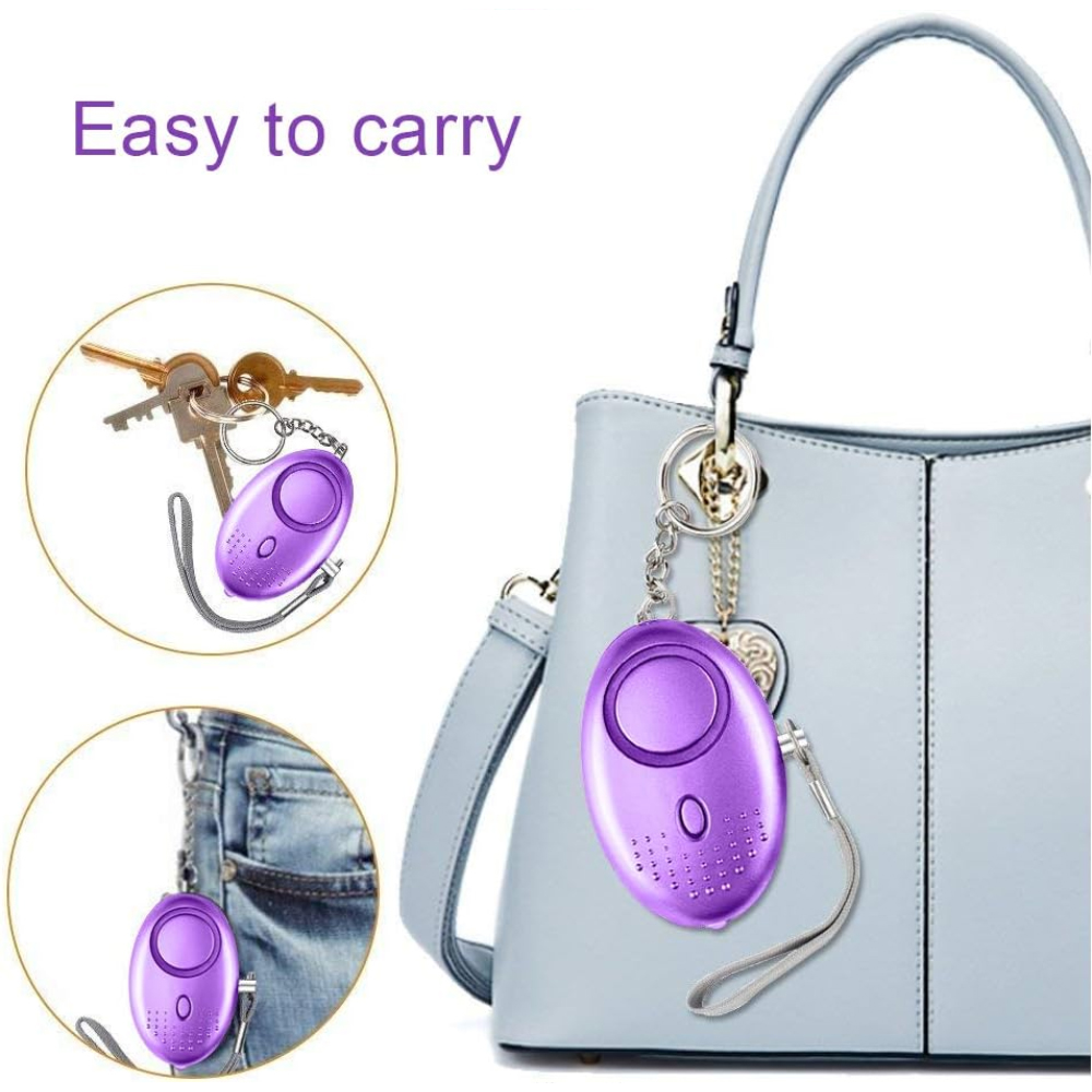 Lila Alarmgerät an einem Schlüsselanhänger, der an einer Handtasche und in einer Tasche hängt.
