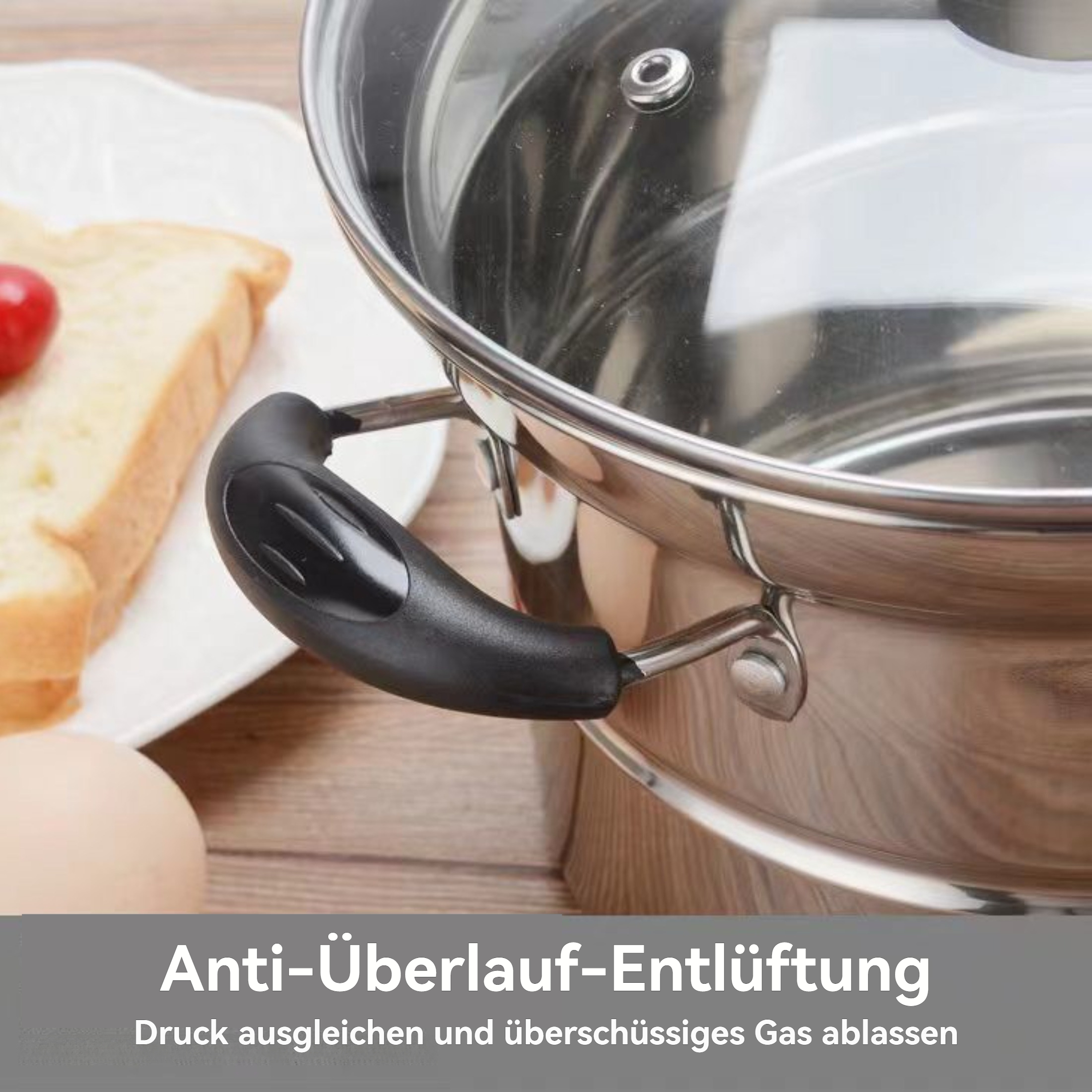 Ein Edelstahltopf mit schwarzem Griff, Deckel und Text. Brot und Ei liegen auf dem Tisch.