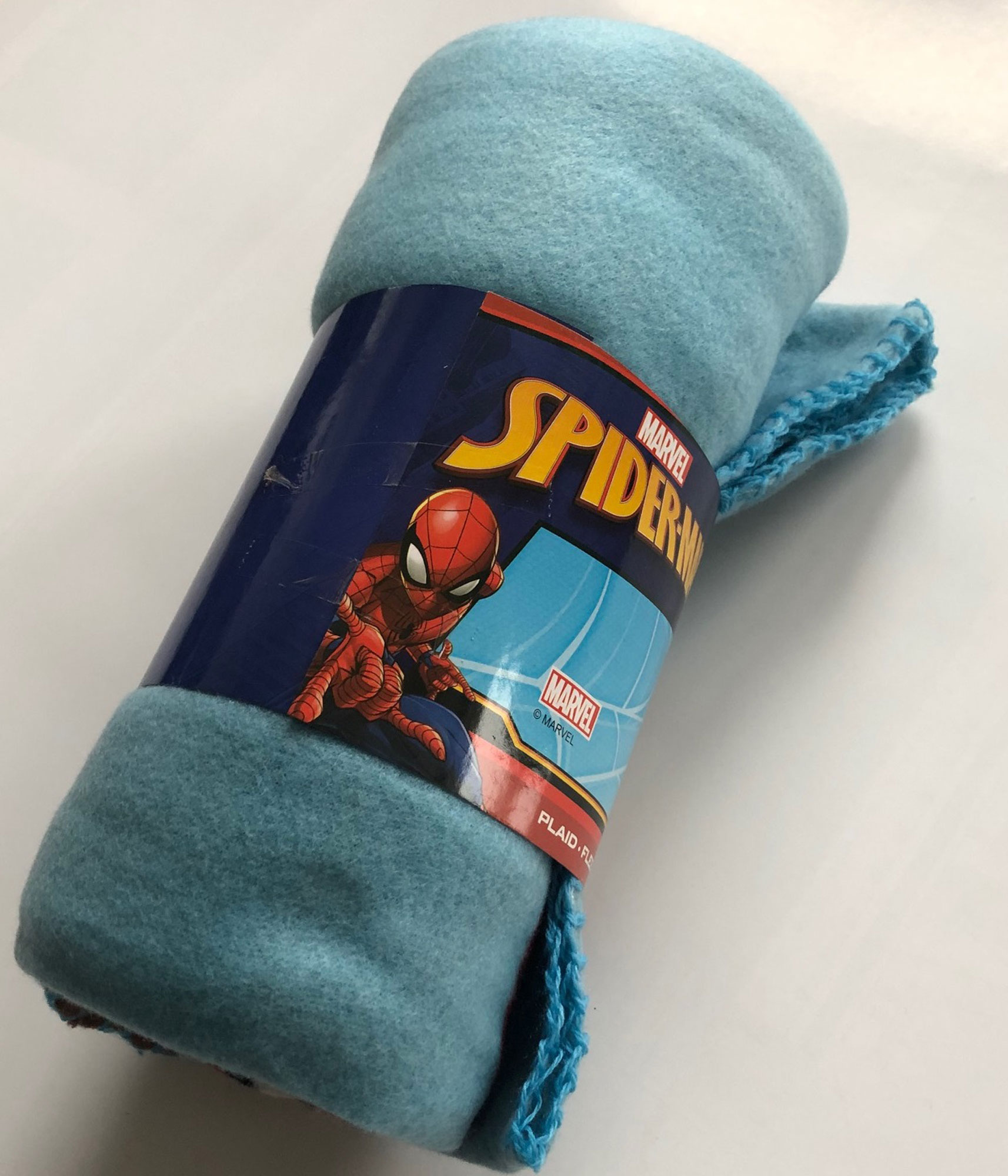 Eine zusammengerollte blaue Spider-Man-Fleece-Decke mit einem Marvel-Logo.