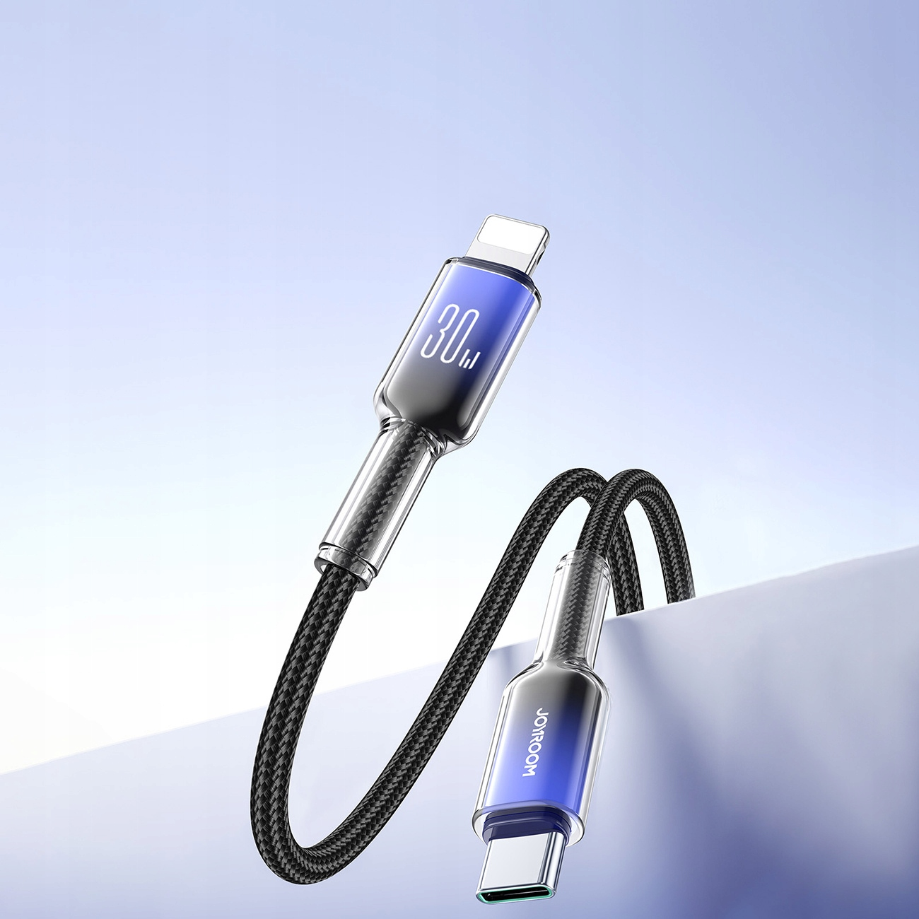 Kabel USB-C do Lightning z czarnym plecionym przewodem oraz srebrnymi i niebieskimi złączami. Niebieskie tło.